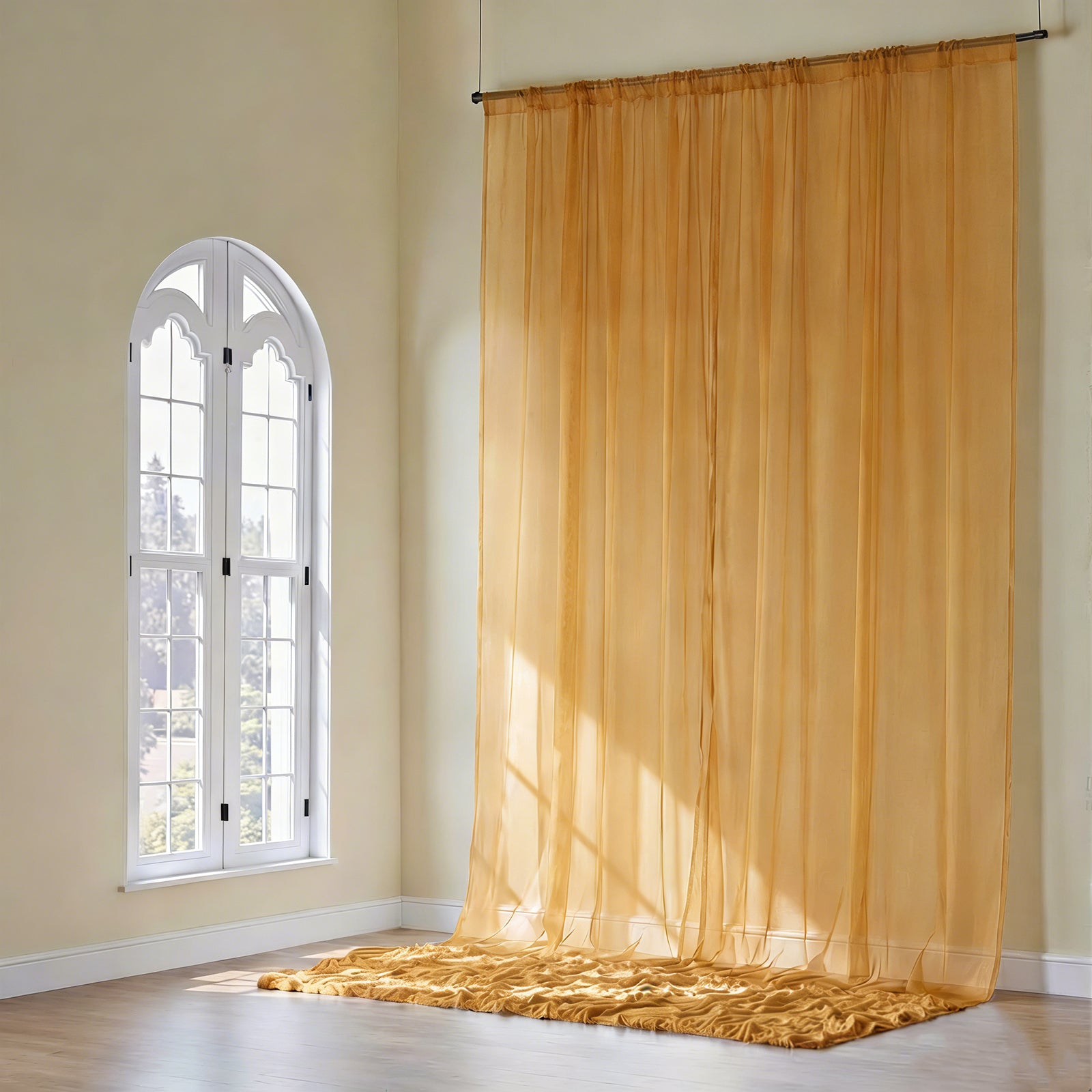 Gold chiffon curtain panel drape in a bright interior setting.