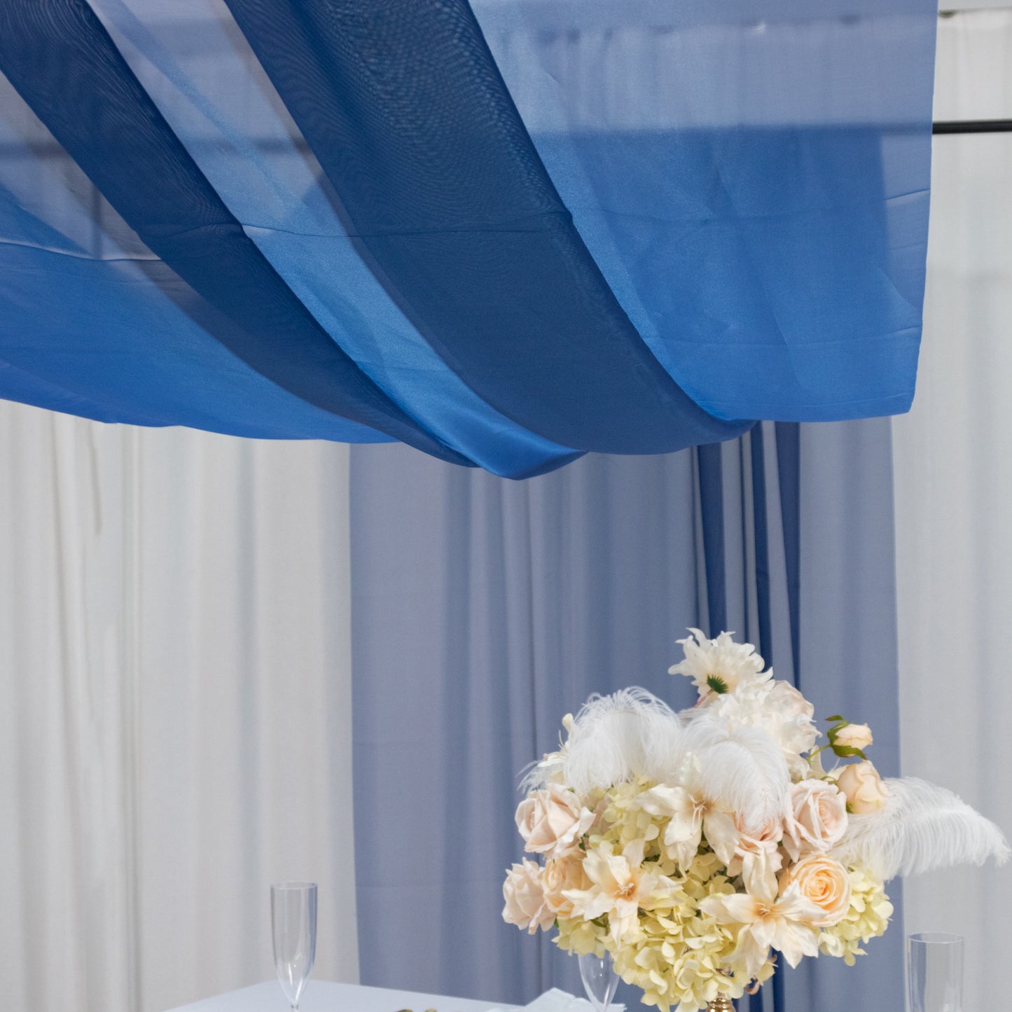 Navy blue chiffon curtain panel draping elegantly above a floral arrangement.