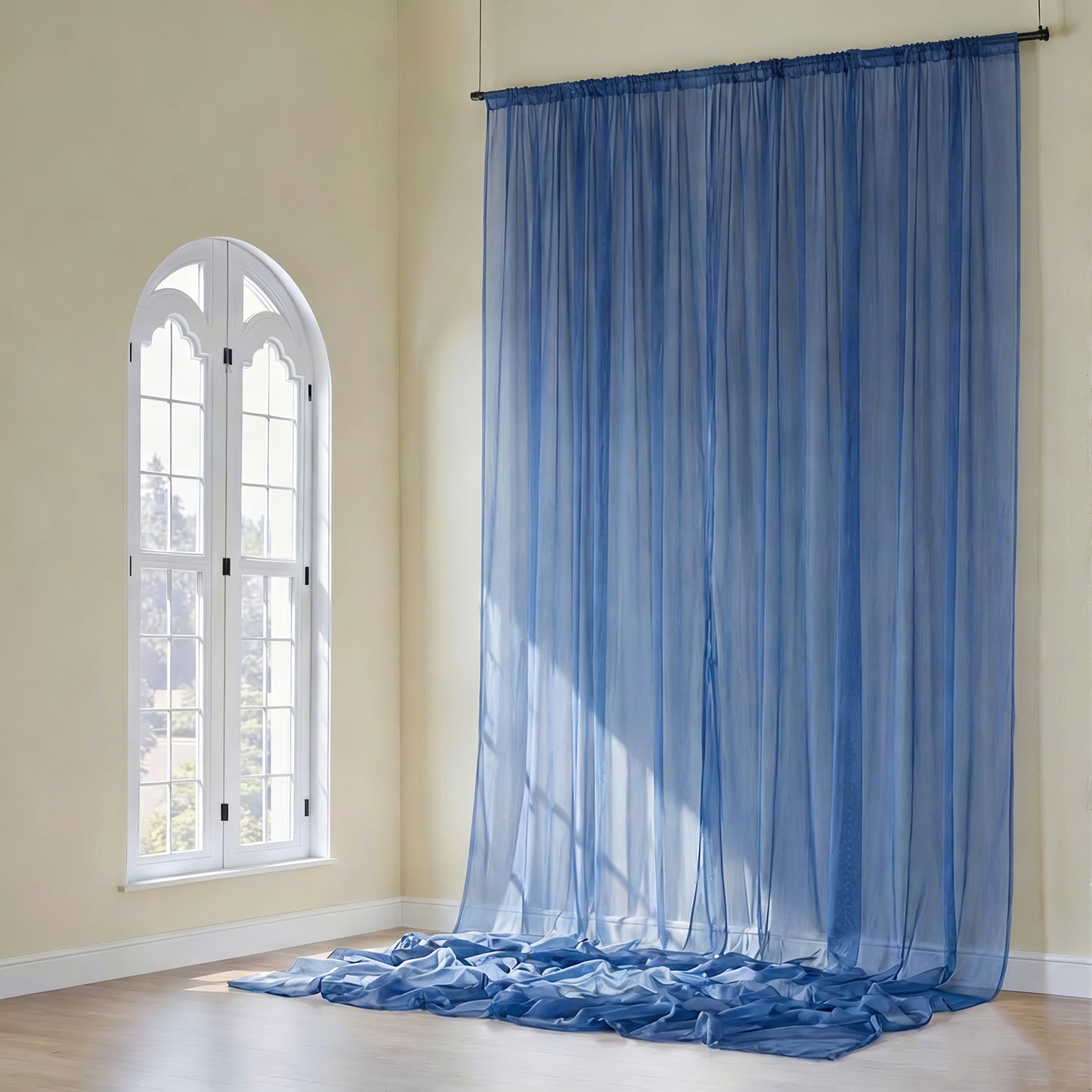 Navy blue chiffon curtain panel draping elegantly in a sunlit room.