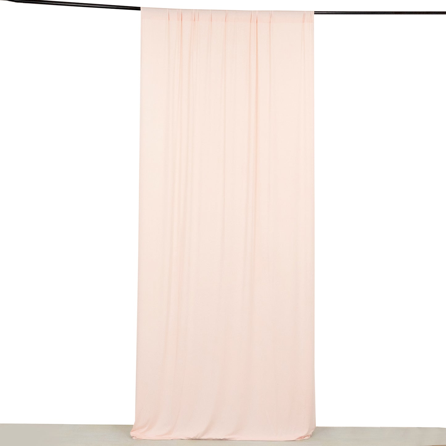 Blush 4-way stretch spandex event curtain drapes hanging on a rod.