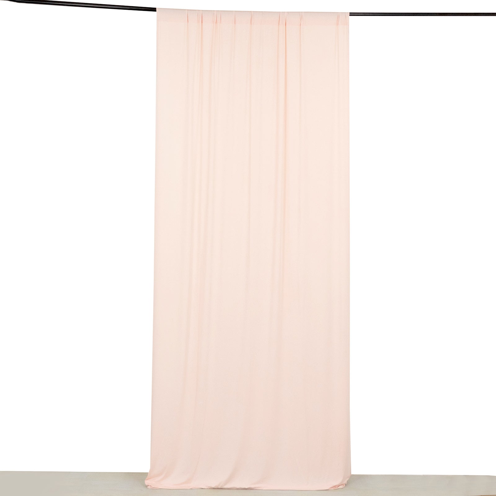 Blush 4-way stretch spandex event curtain drapes hanging on a rod.