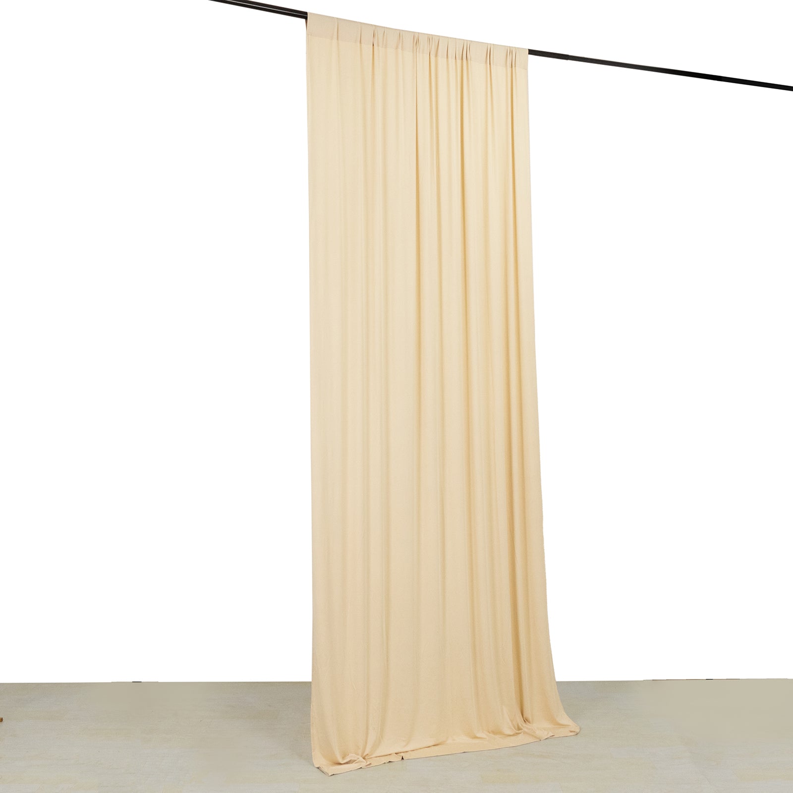 Beige 4-way stretch spandex event curtain drapes on a rod.