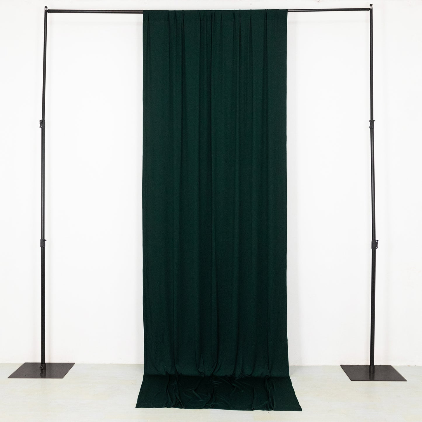 Emerald green 4-way stretch spandex event curtain drapes on a backdrop stand.