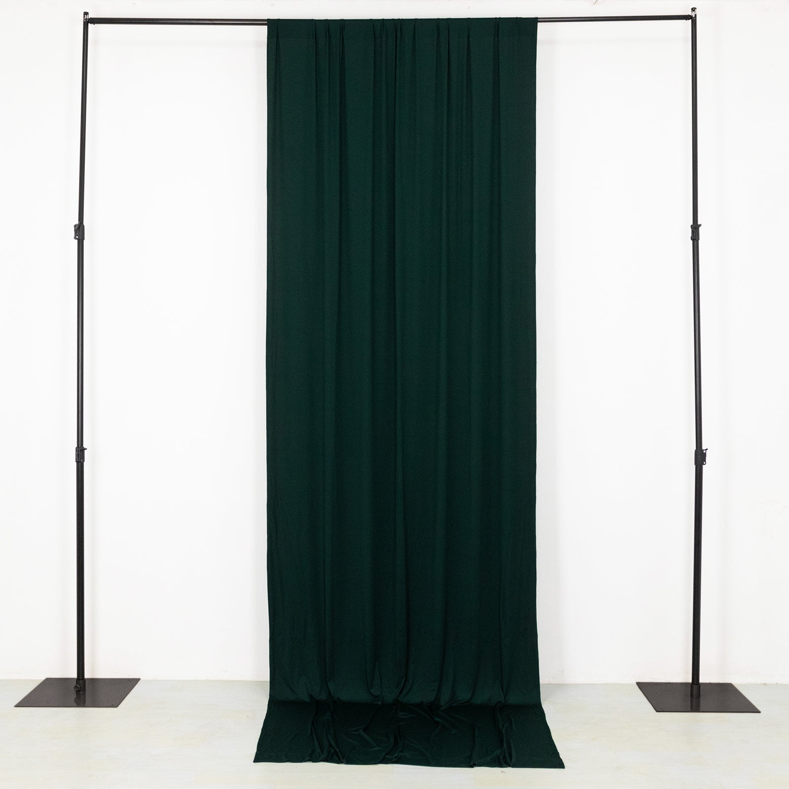 Emerald green 4-way stretch spandex event curtain drapes on a backdrop stand.