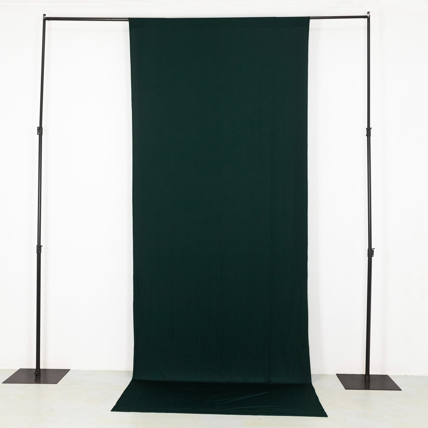 Emerald green 4-way stretch spandex event curtain drapes on a backdrop stand.