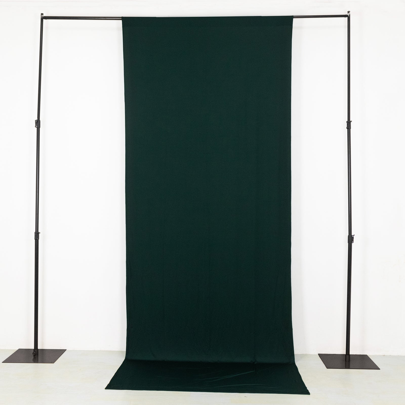 Emerald green 4-way stretch spandex event curtain drapes on a backdrop stand.