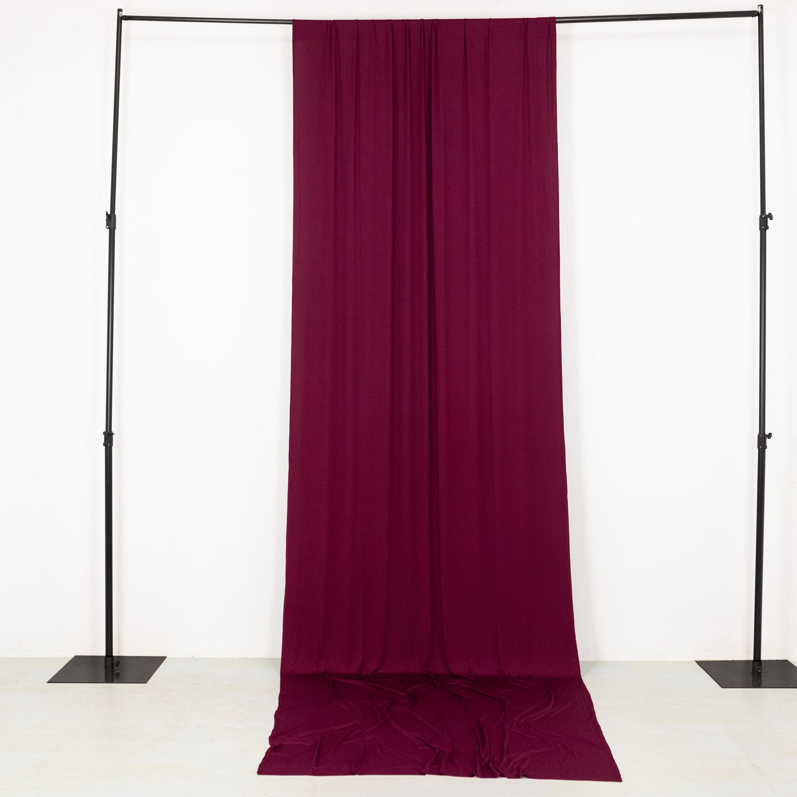 Burgundy 4-way stretch spandex event curtain drapes on a backdrop stand.