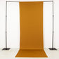 Gold stretch spandex event curtain drapes on a backdrop stand.