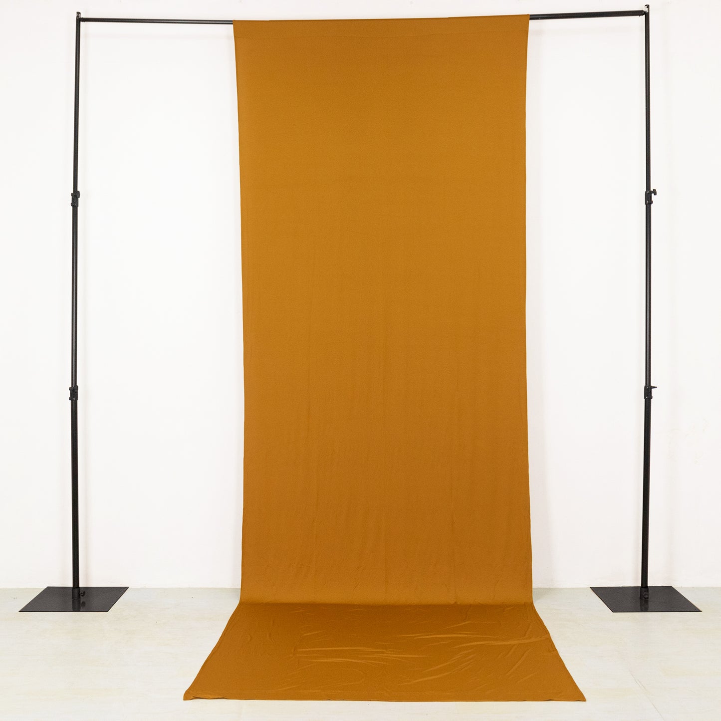 Gold stretch spandex event curtain drapes on a backdrop stand.