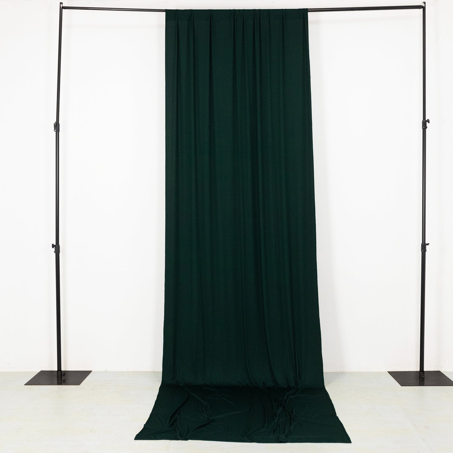 Emerald green 4-way stretch spandex event curtain drapes on a backdrop stand.