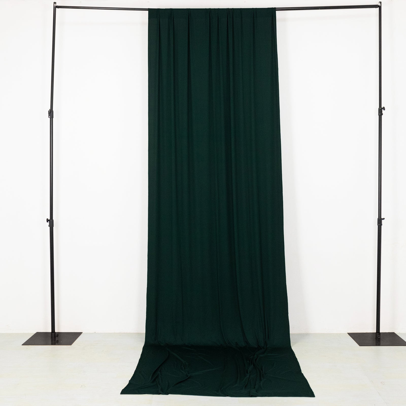 Emerald green 4-way stretch spandex event curtain drapes on a backdrop stand.