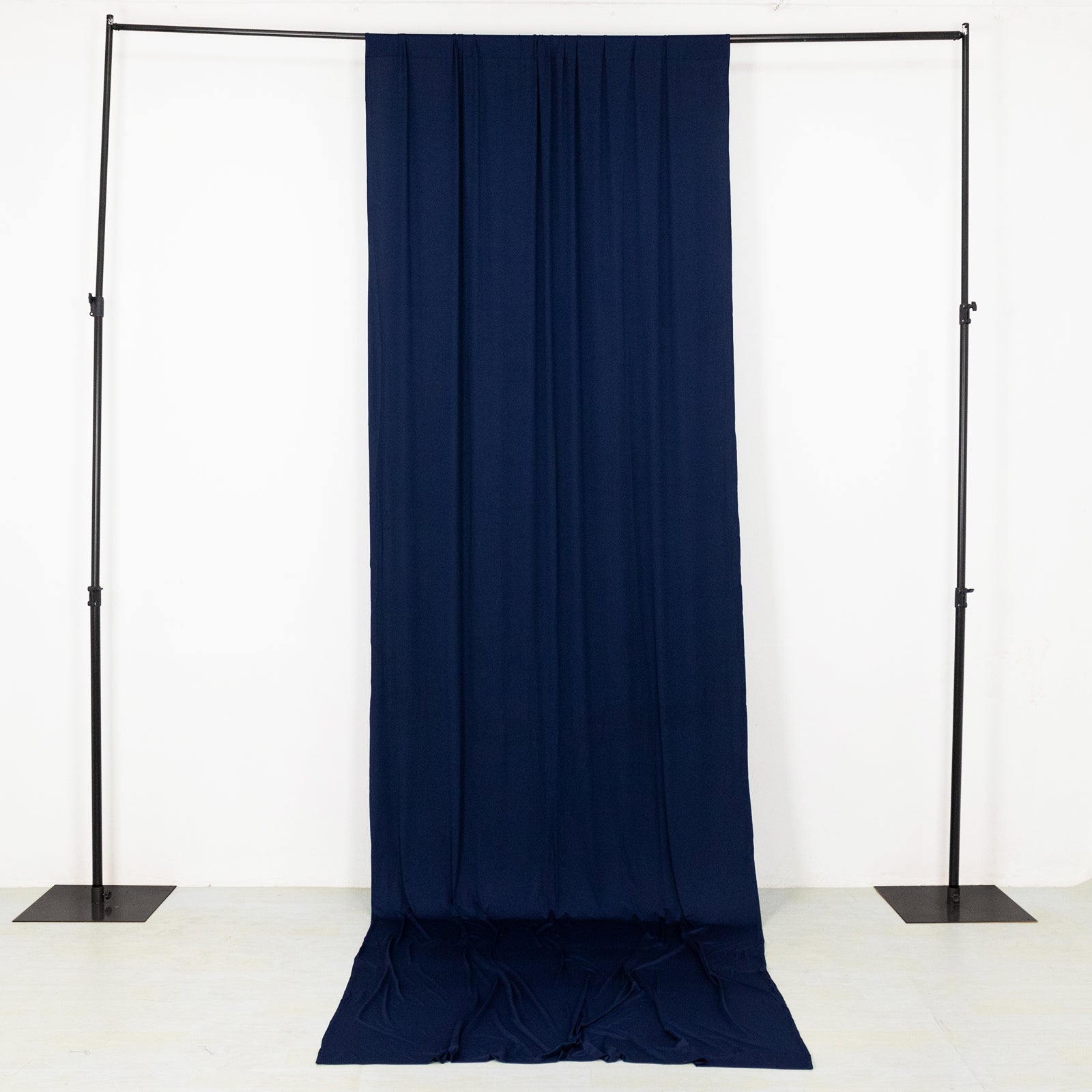 Navy blue 4-way stretch spandex event curtain drapes on a backdrop stand.