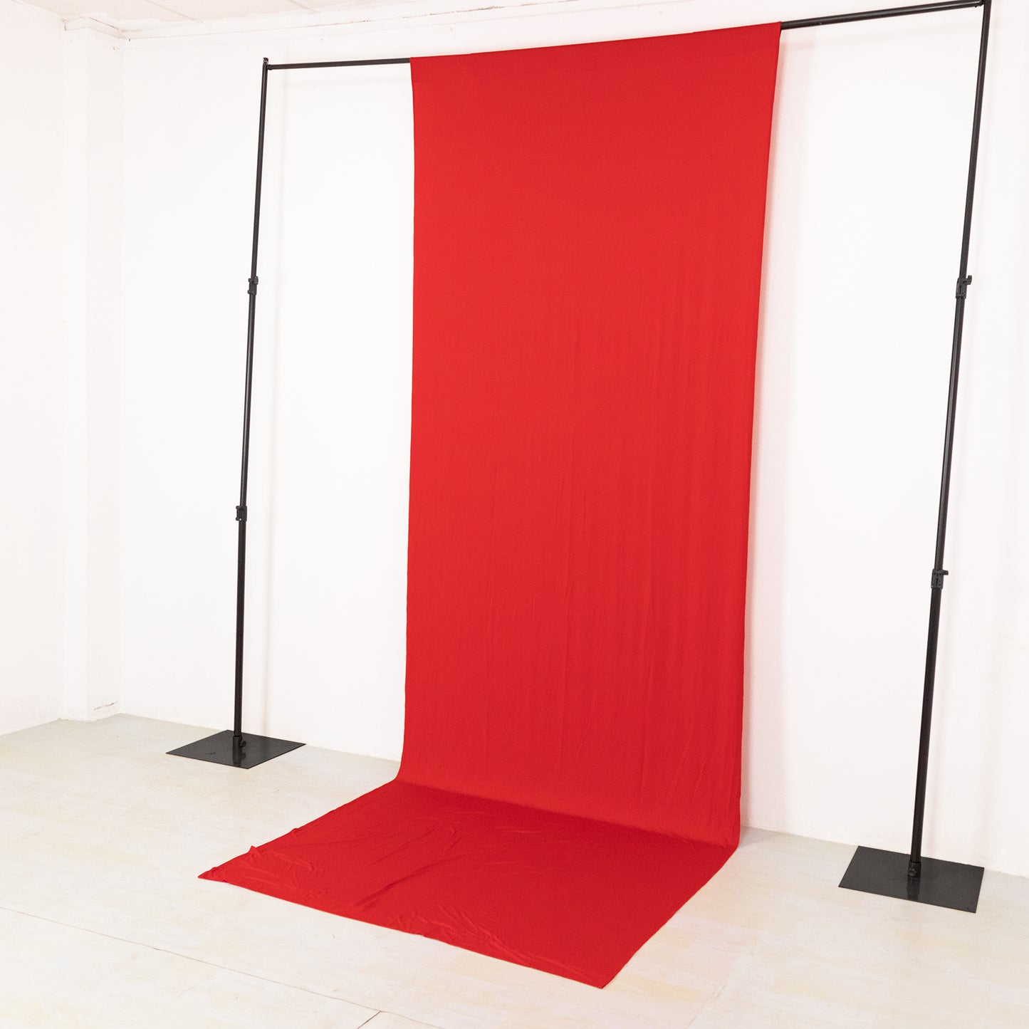 Red 4-way stretch spandex event curtain drapes on a backdrop stand.