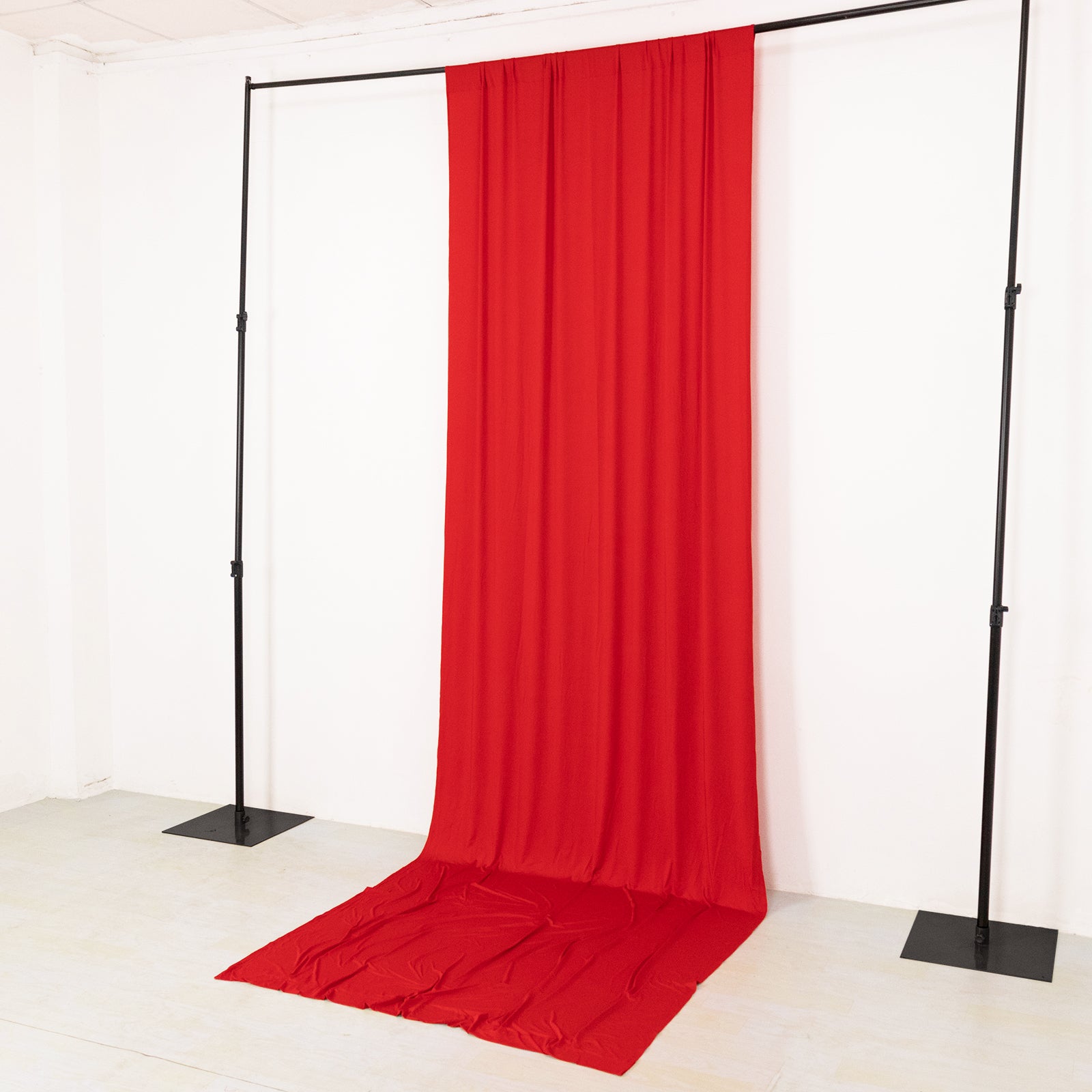 Red 4-way stretch spandex event curtain drapes on a backdrop stand.