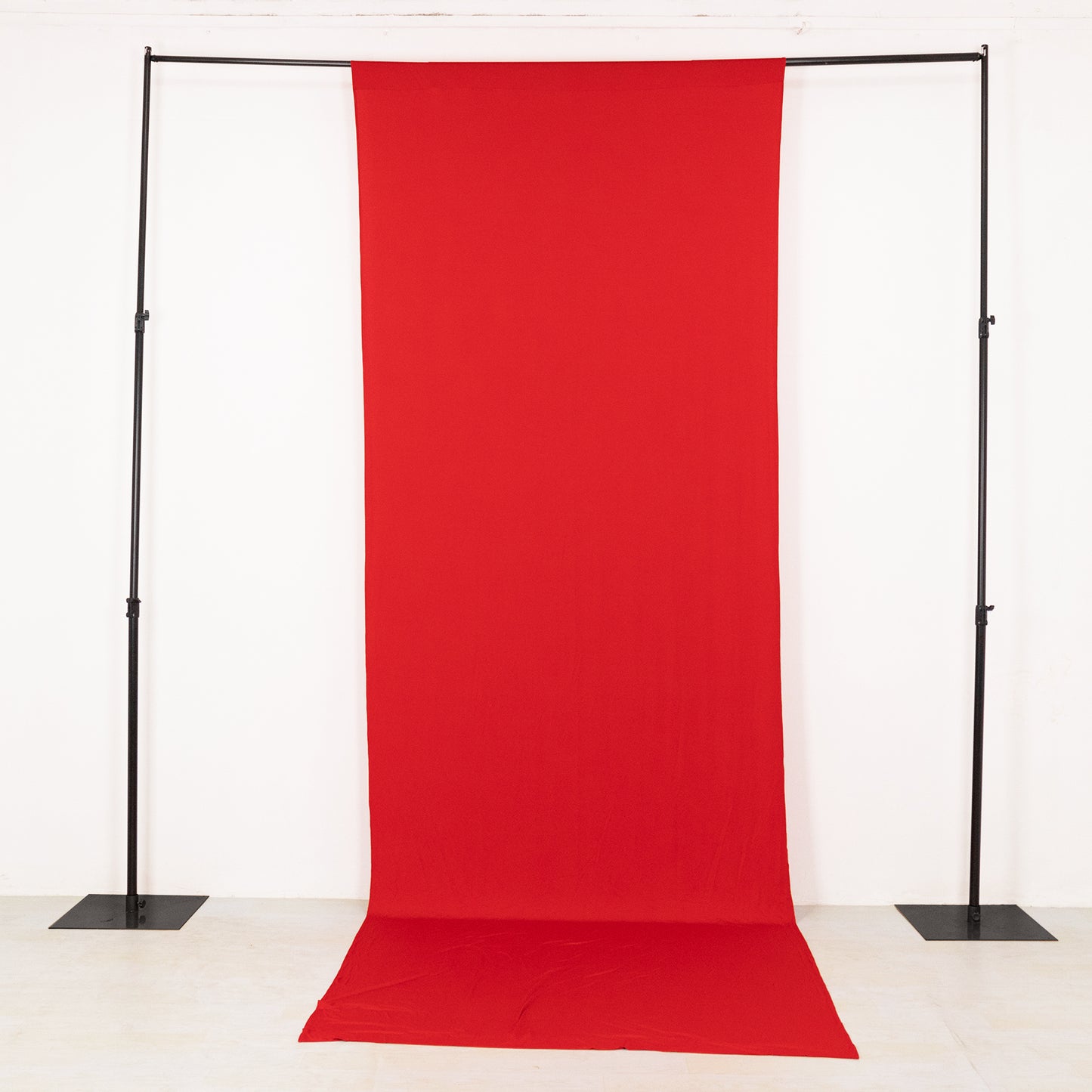 Red 4-way stretch spandex event curtain drapes on a backdrop stand.