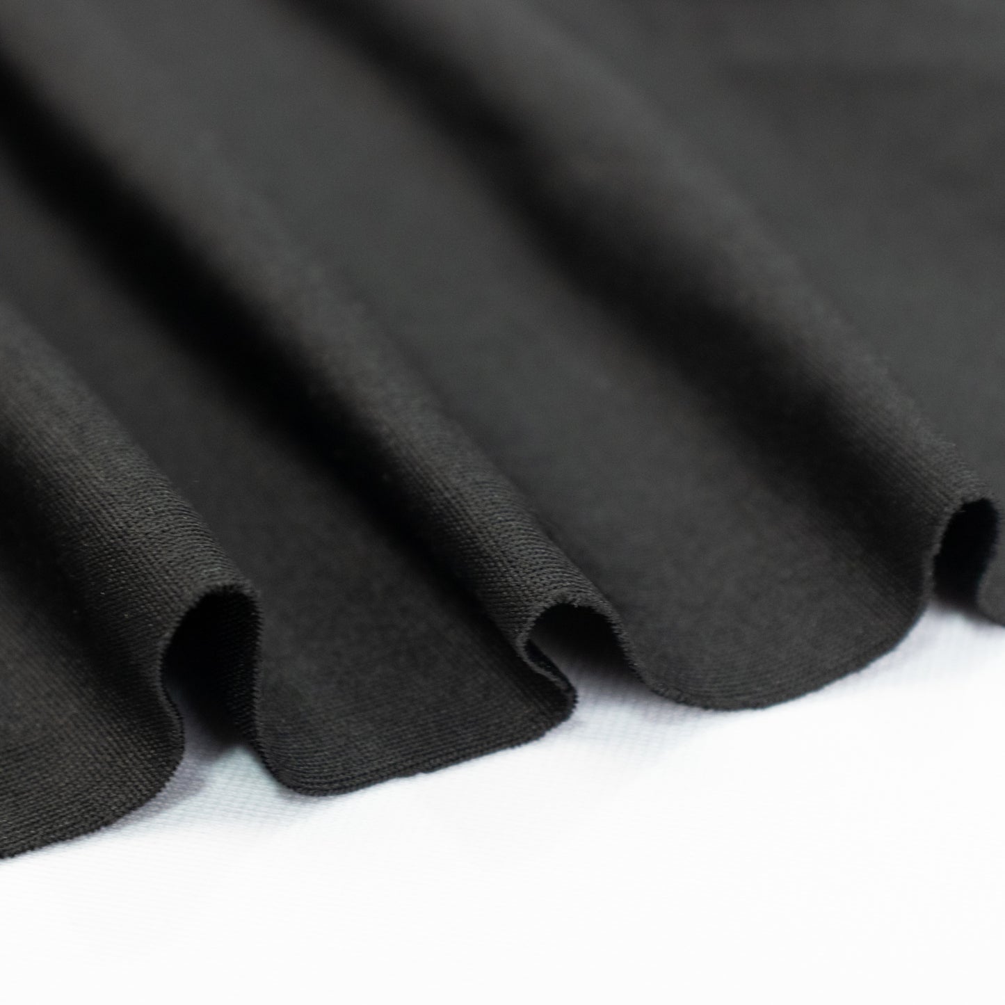 Black stretch spandex tent ceiling drape fabric with a smooth finish.