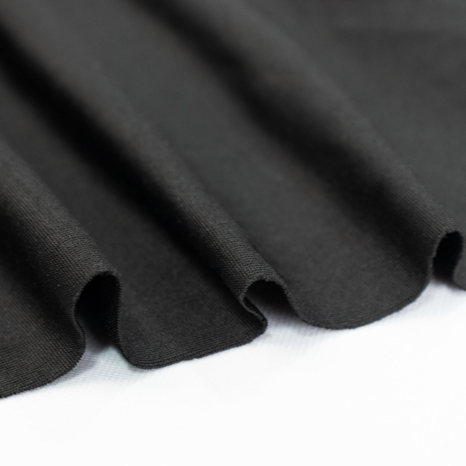 Black stretch spandex tent ceiling drape fabric with a smooth finish.