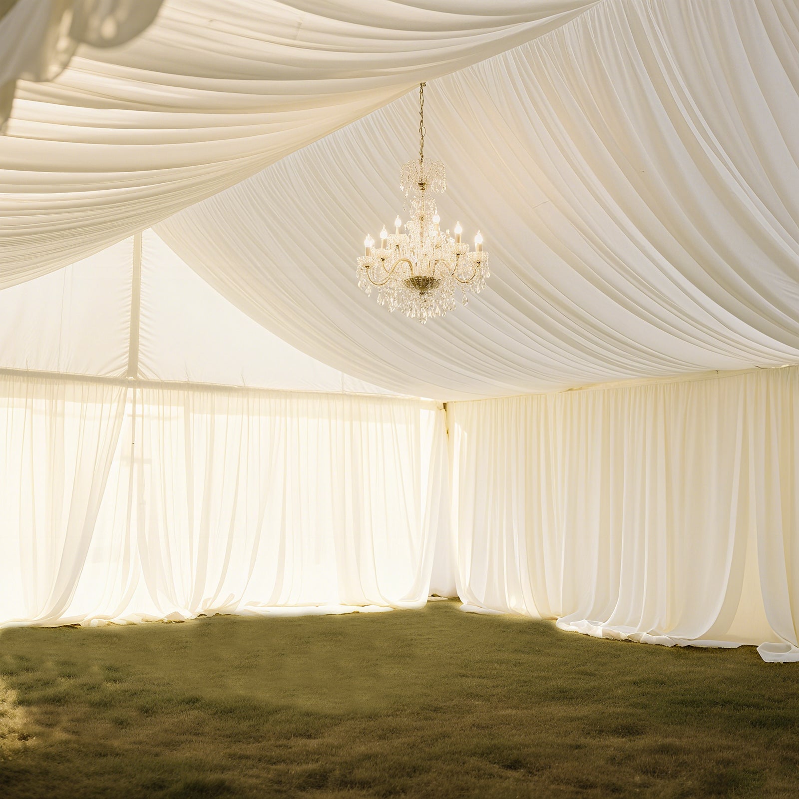 Ivory stretch spandex tent ceiling drape with chandelier in a tent setting.