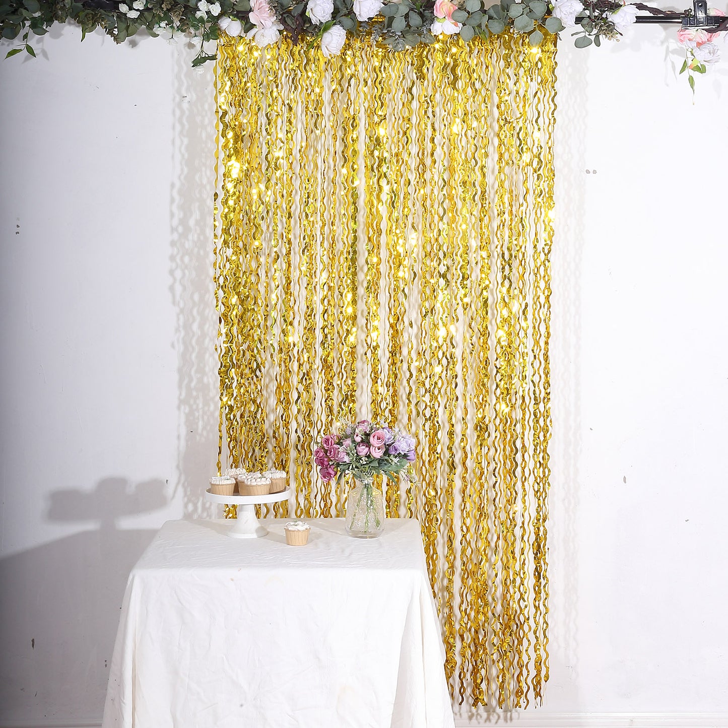 Metallic gold wavy foil fringe backdrop curtain for party photo booths.