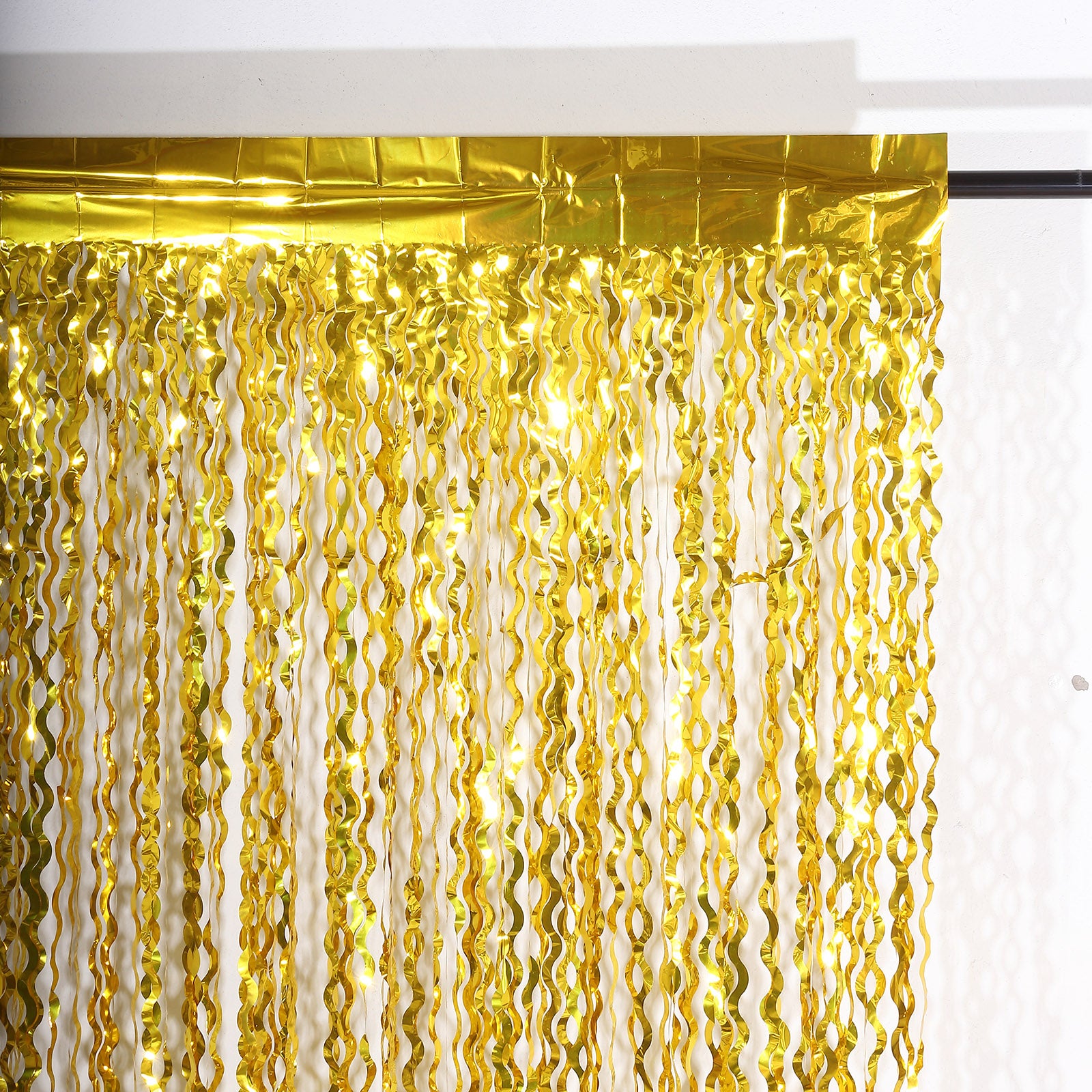 Metallic gold wavy foil fringe party backdrop curtain.