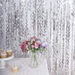 Metallic silver wavy foil fringe backdrop with curly tinsel streamers.
