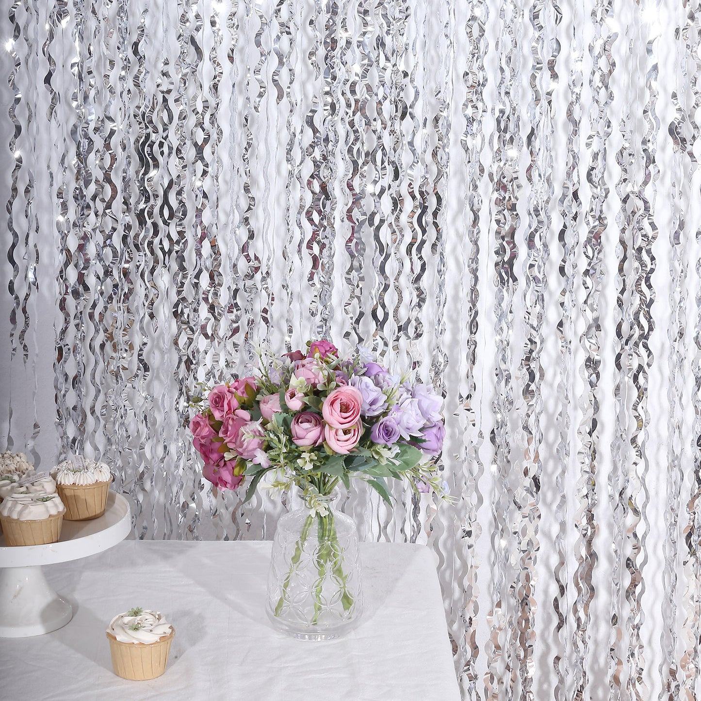 Metallic silver wavy foil fringe backdrop with curly tinsel streamers.