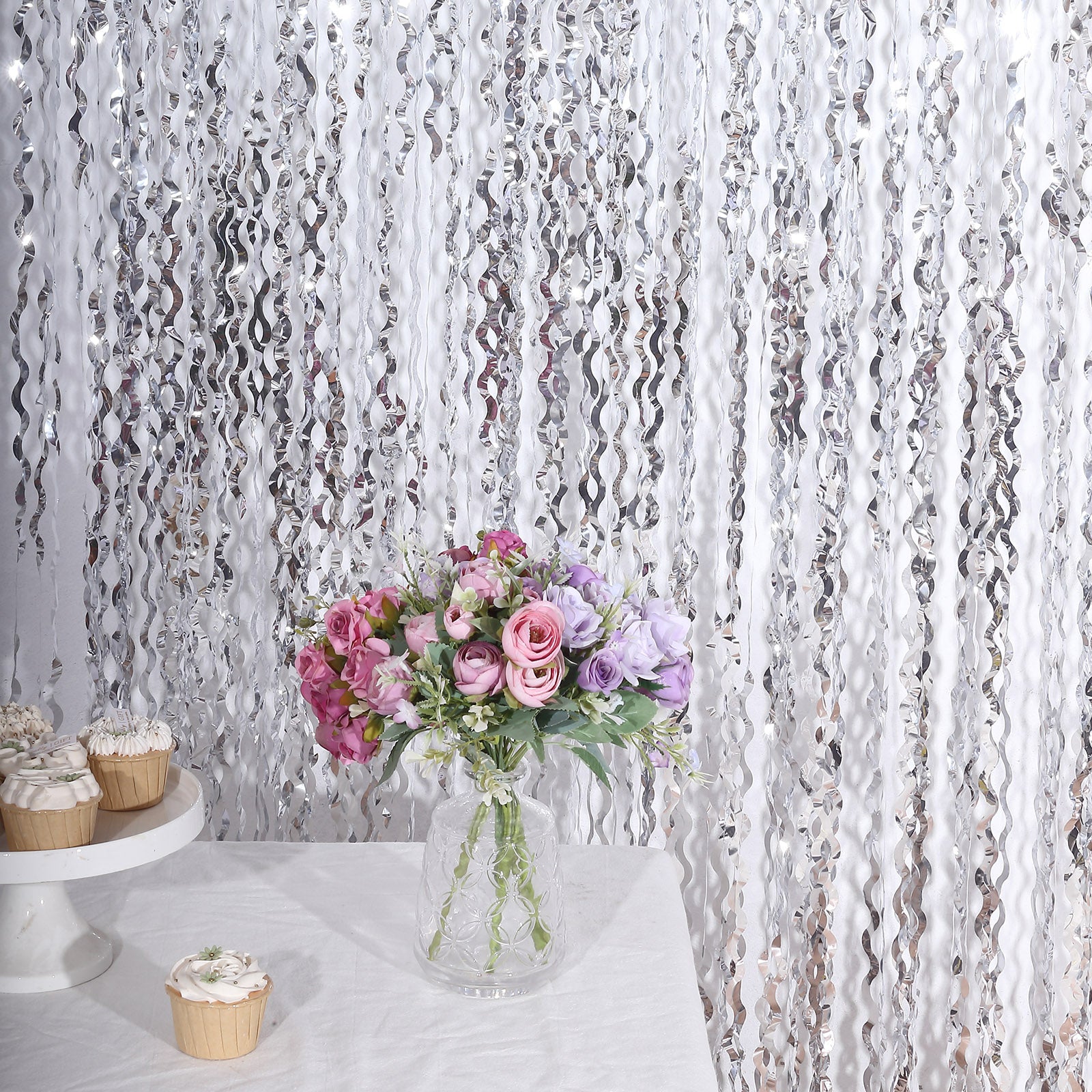 Metallic silver wavy foil fringe backdrop with curly tinsel streamers.