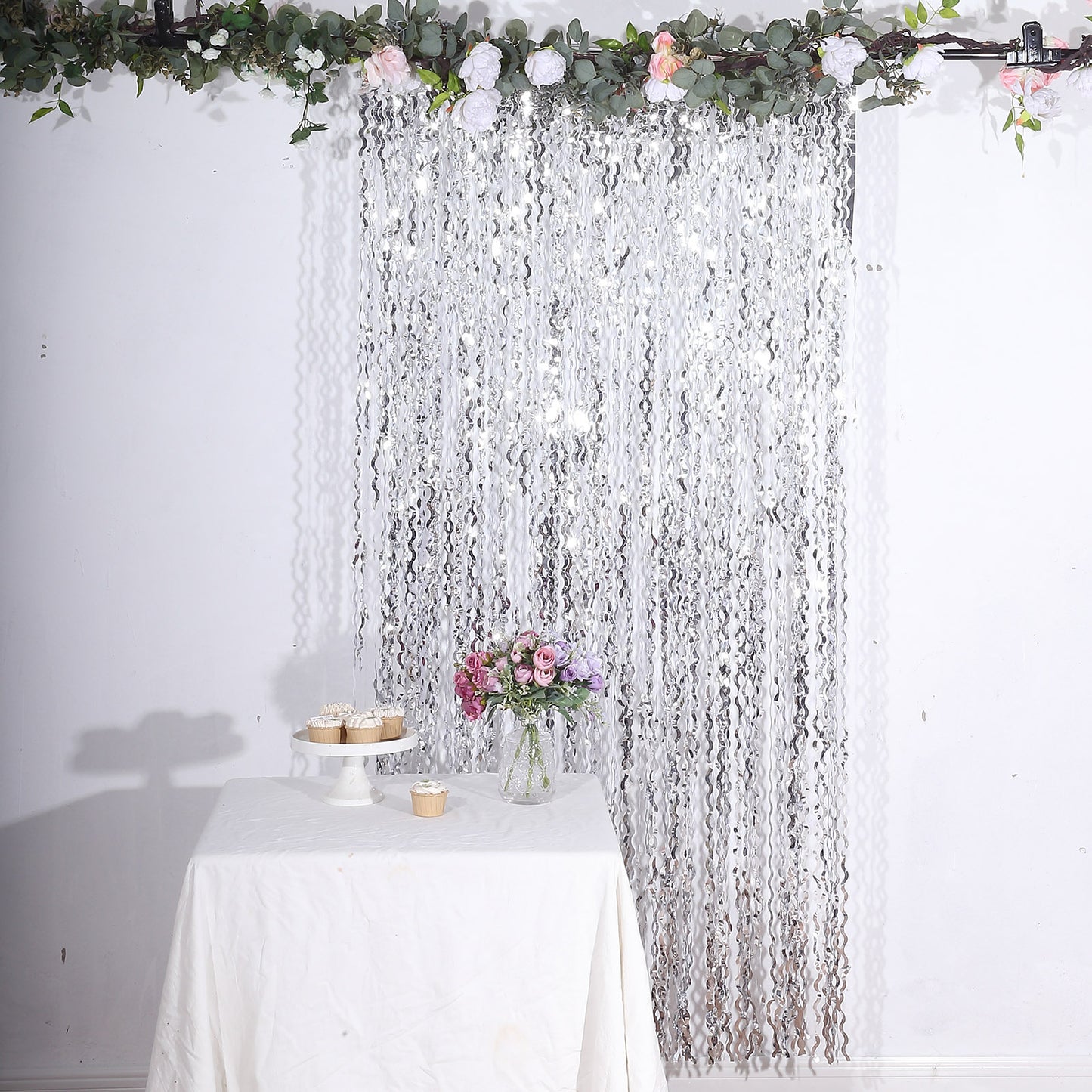 Metallic silver wavy foil fringe backdrop curtain for parties and photo booths.