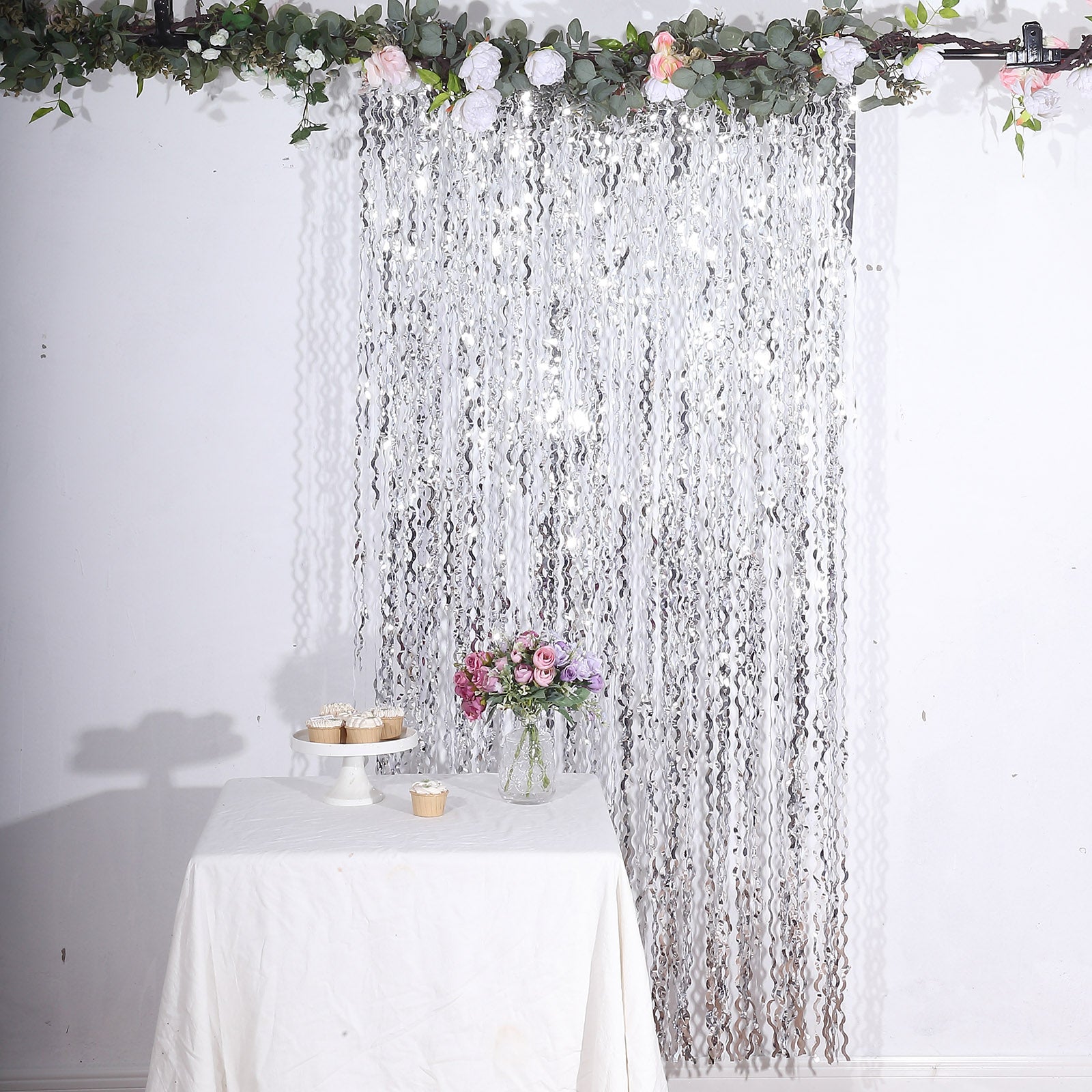 Metallic silver wavy foil fringe backdrop curtain for parties and photo booths.