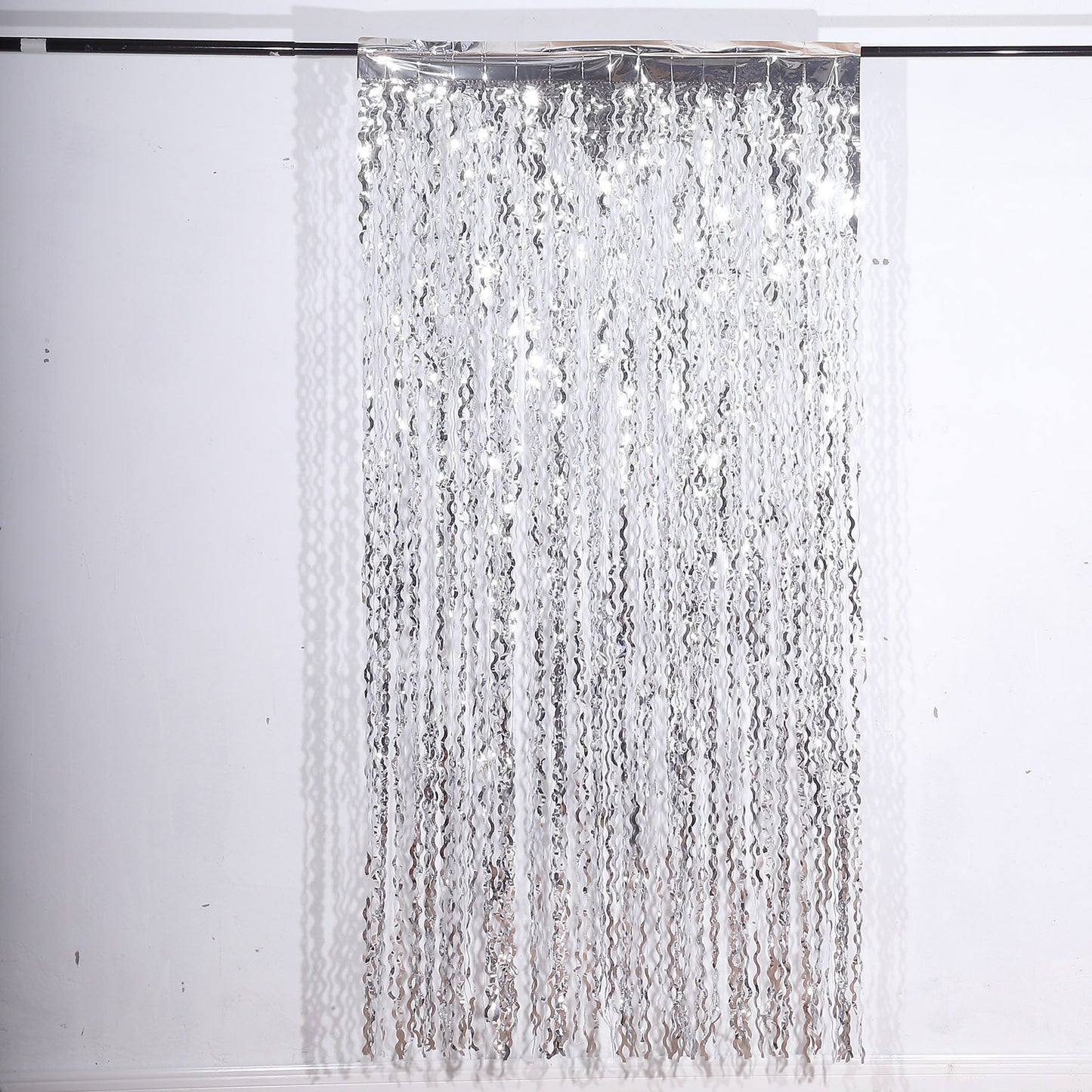 Metallic silver wavy foil fringe party backdrop curtain.