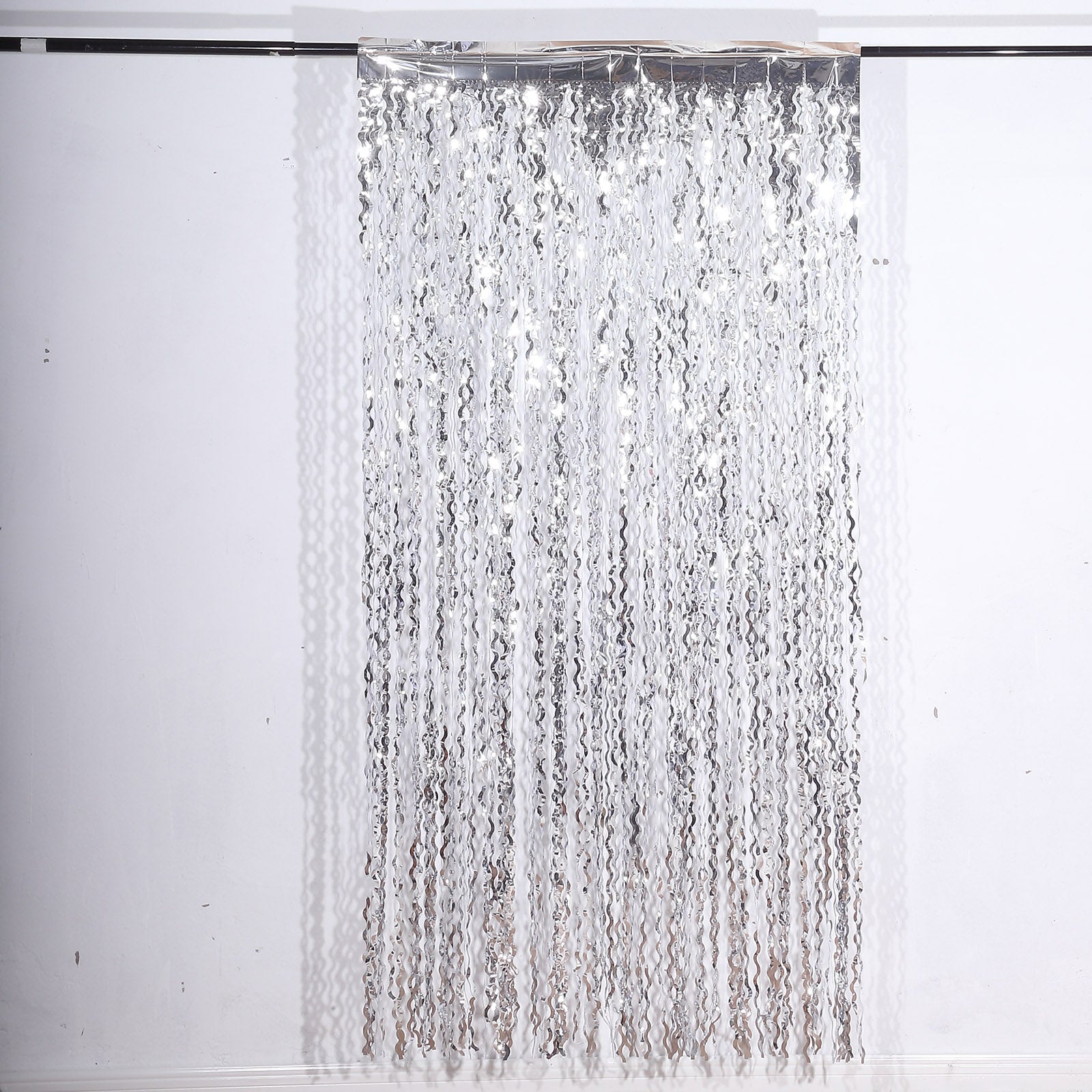 Metallic silver wavy foil fringe party backdrop curtain.