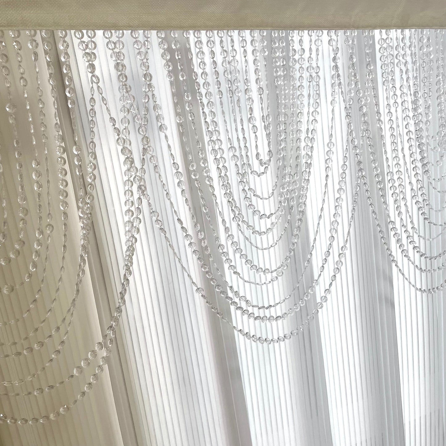 Clear acrylic crystal beaded curtain valance with triple swag design.