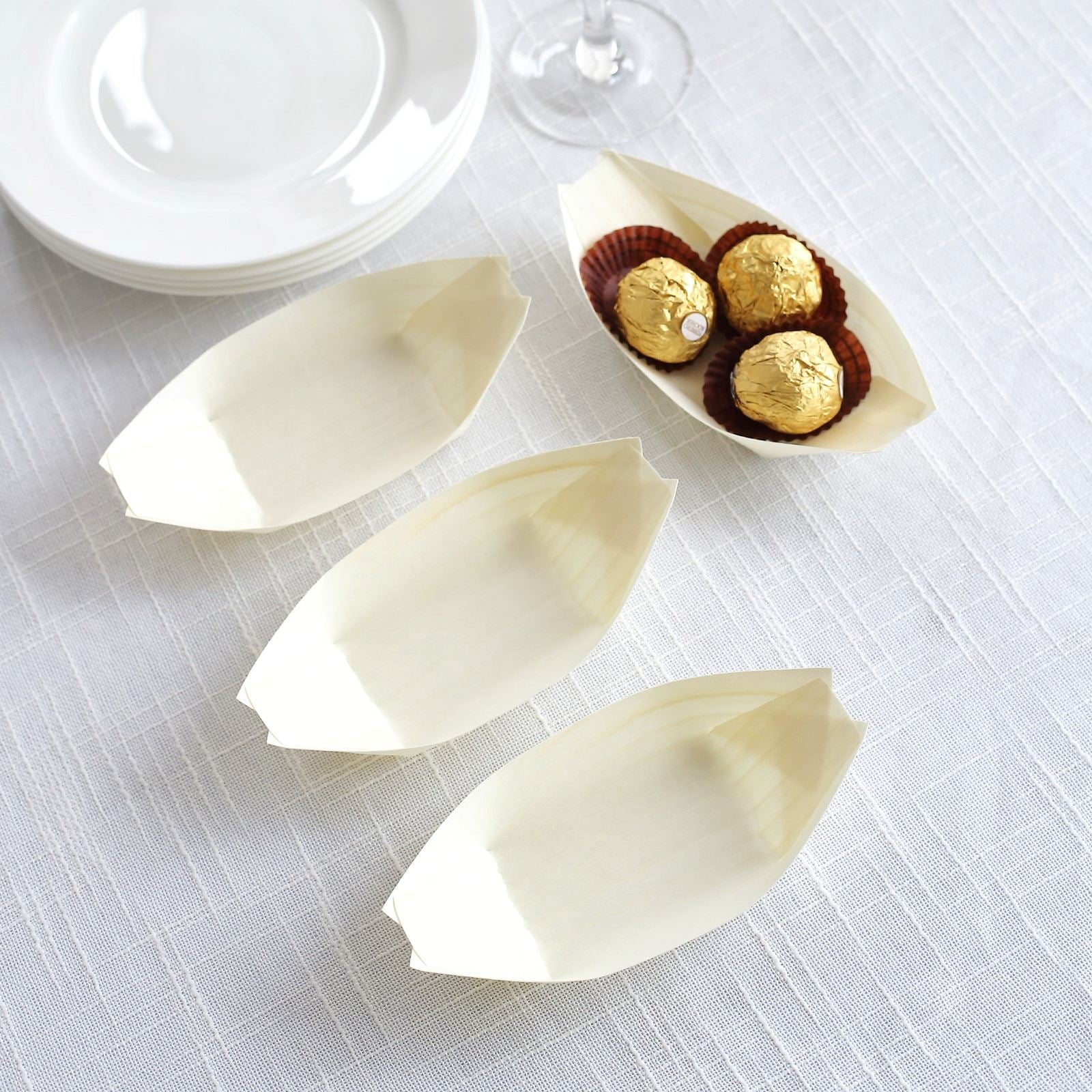 Natural biodegradable wooden boat-shaped plates in cream color.
