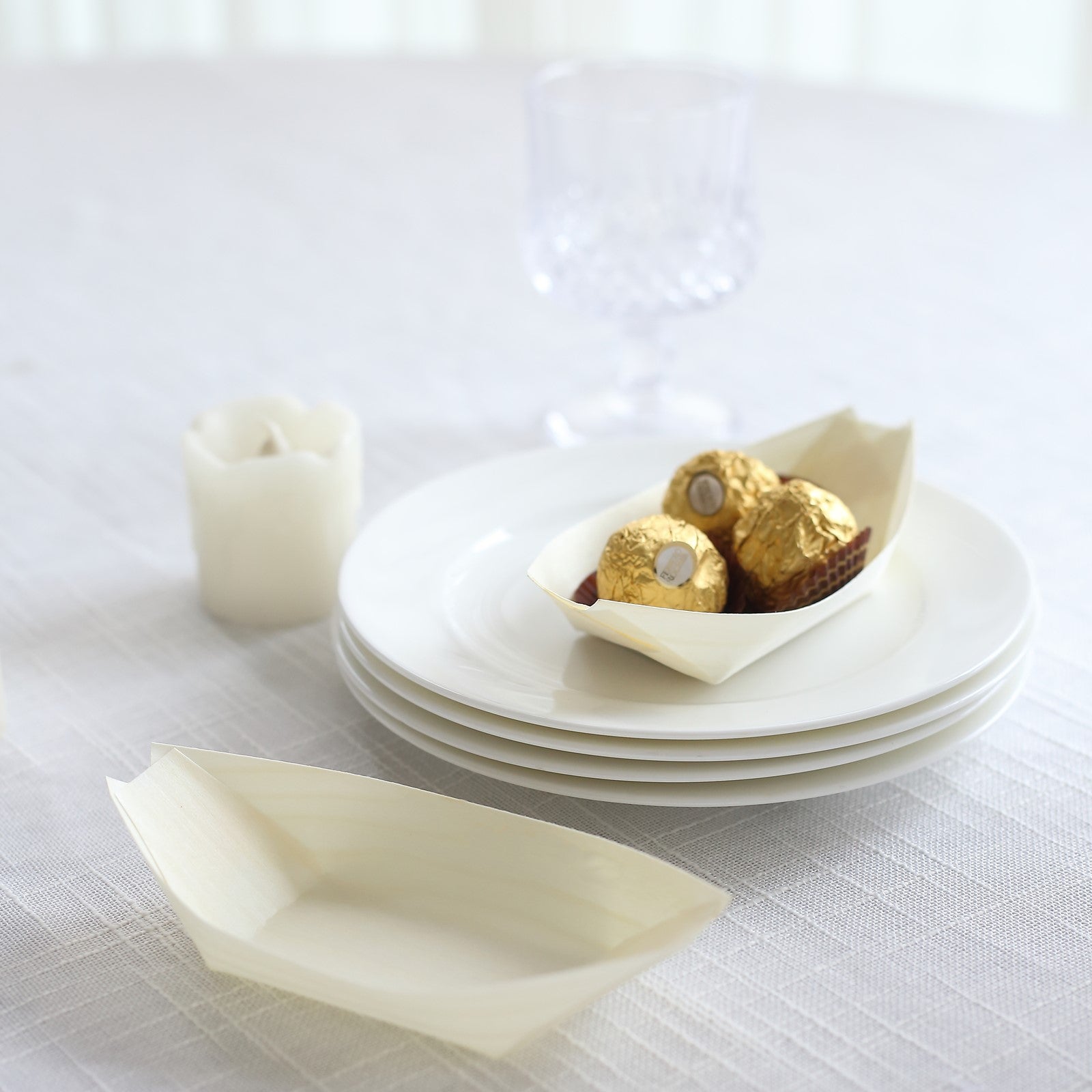 Natural biodegradable wooden boat-shaped food plates on a table.