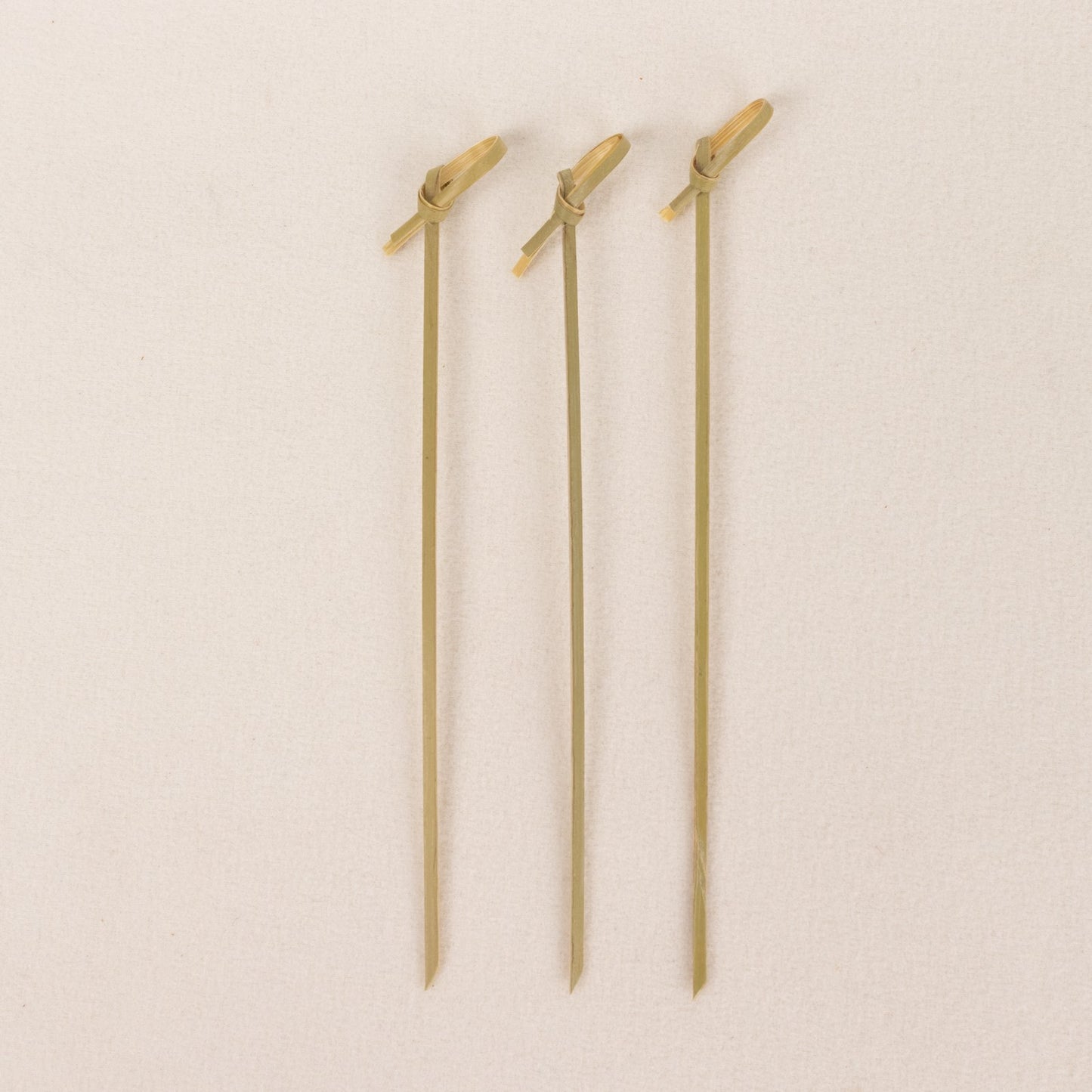 Eco-friendly twisted knot cocktail sticks, light brown bamboo party picks.