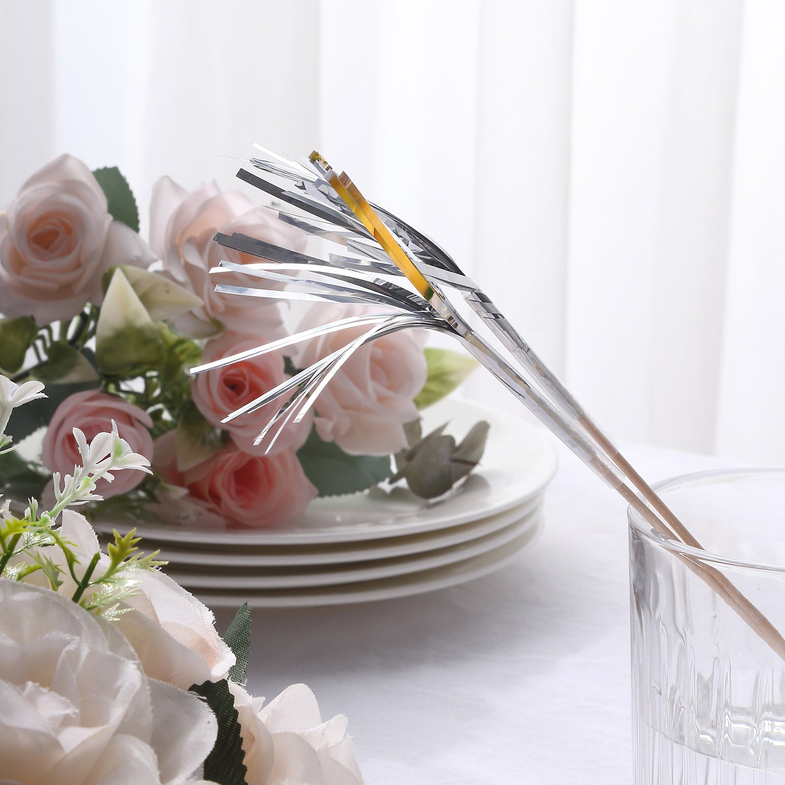 Silver firework frills cake toppers with bamboo sticks and floral background.