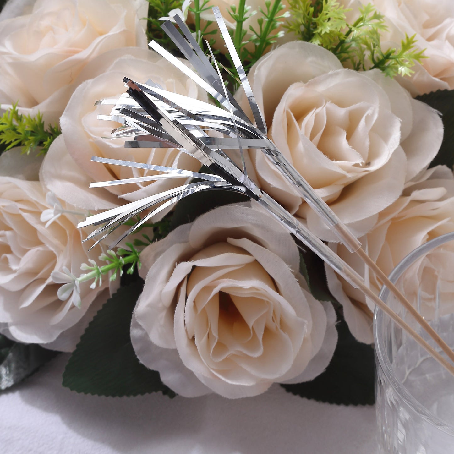 Silver firework frills cake toppers with flowers backdrop.