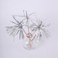 Silver firework frills cake toppers in a glass vase.