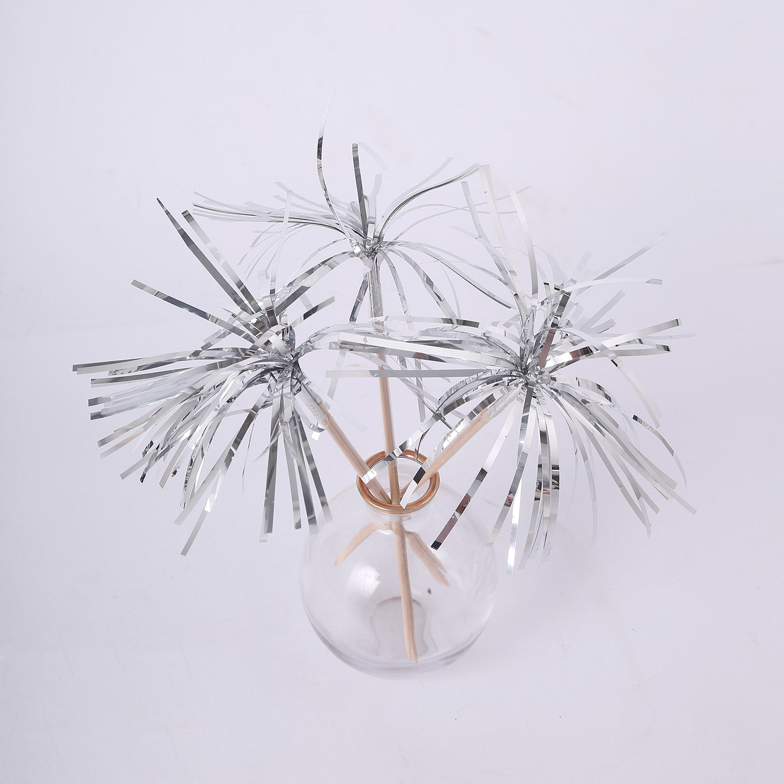 Silver firework frills cake toppers in a glass vase.