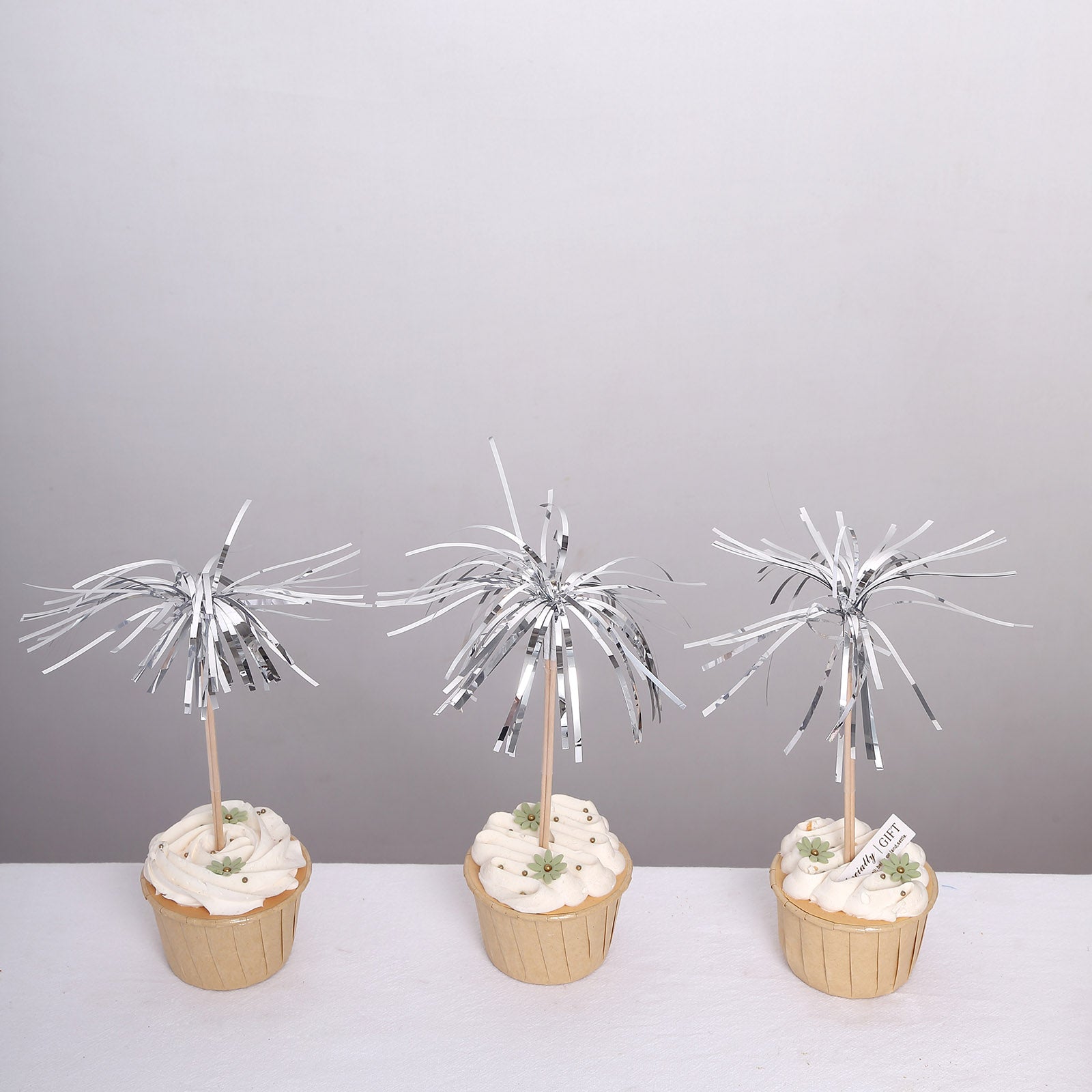 Silver firework frills cake toppers on cupcakes.
