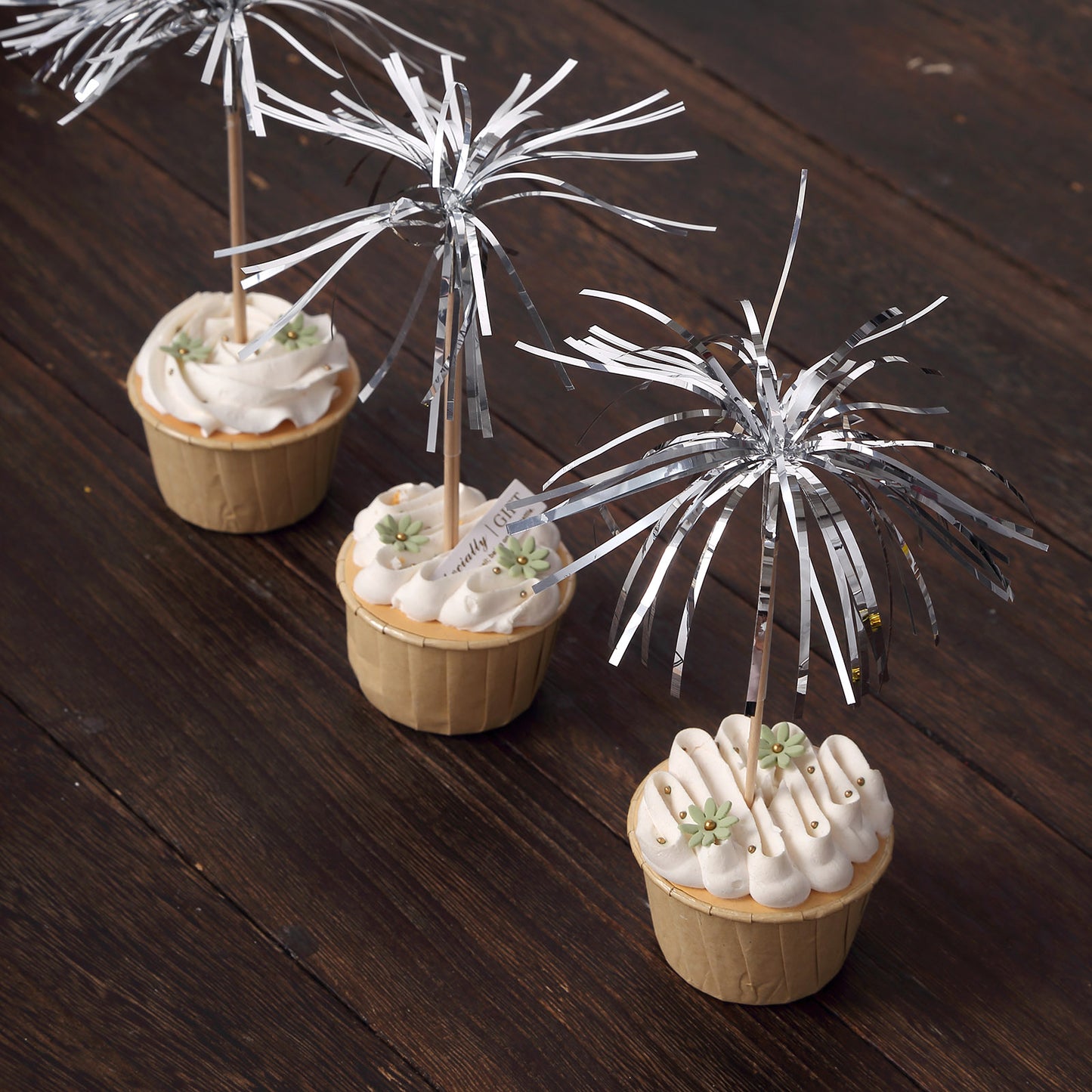 Silver firework frills cake toppers on cupcakes for festive decoration.