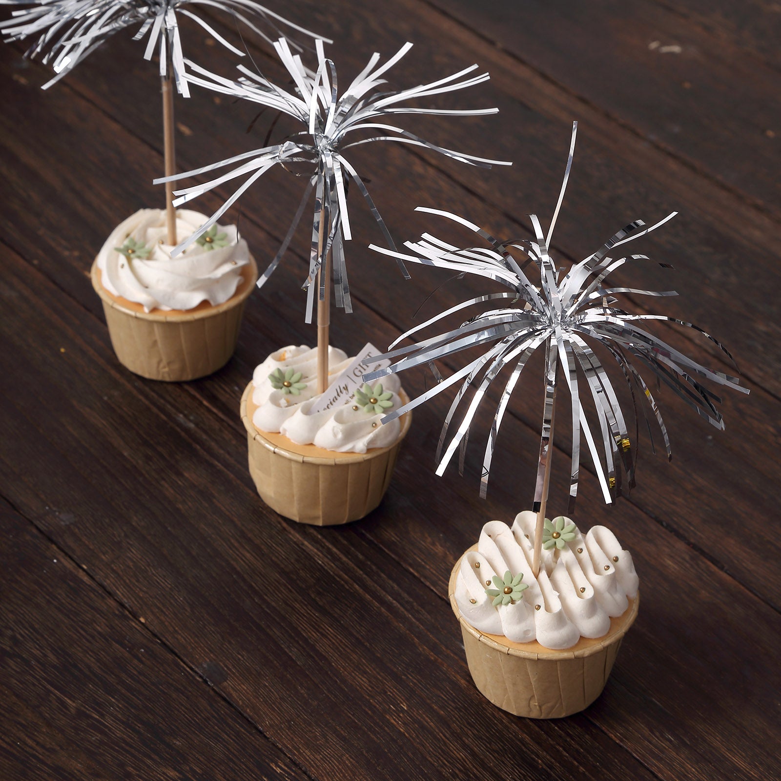 Silver firework frills cake toppers on cupcakes for festive decoration.