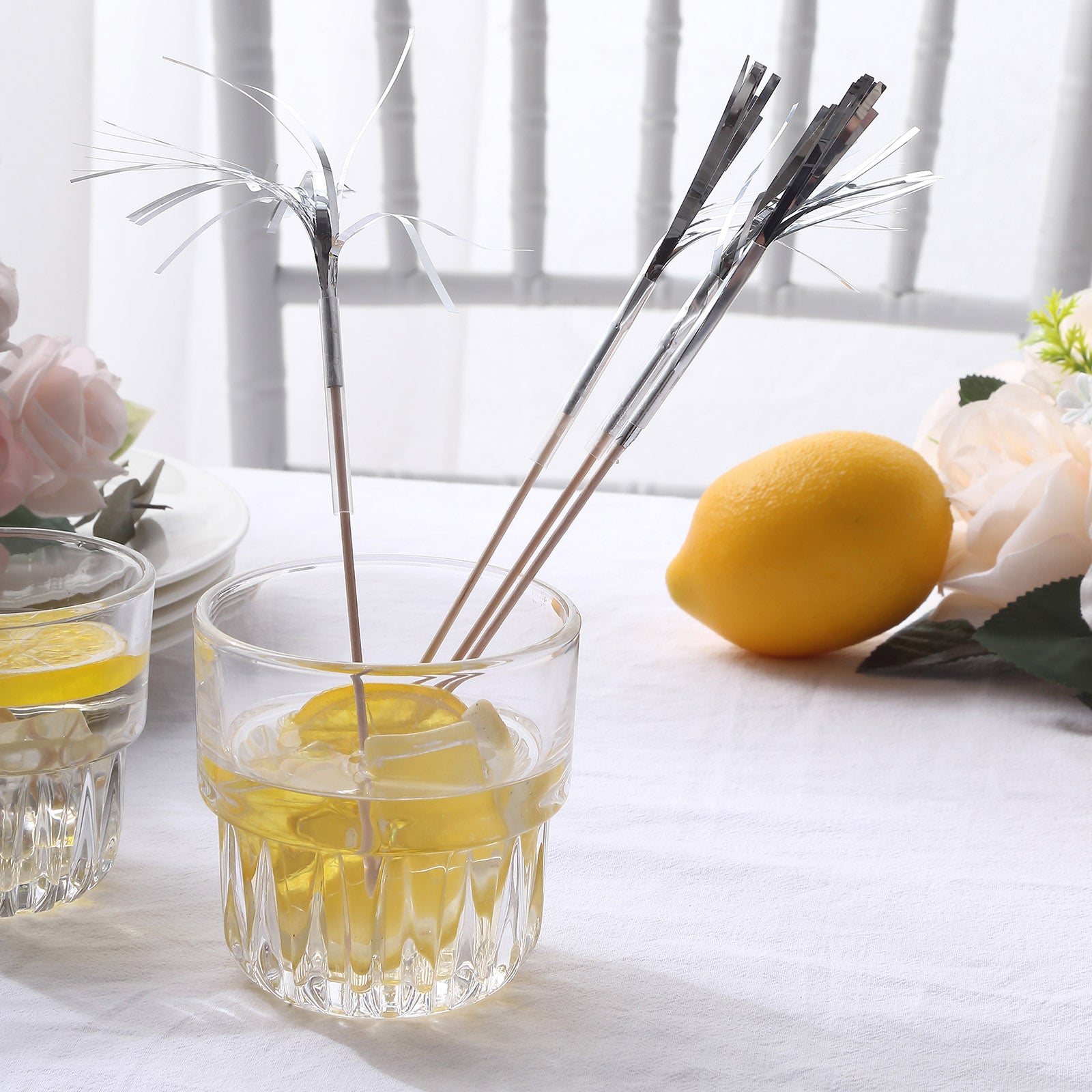 Silver firework frills cake toppers in a cocktail glass with lemon.
