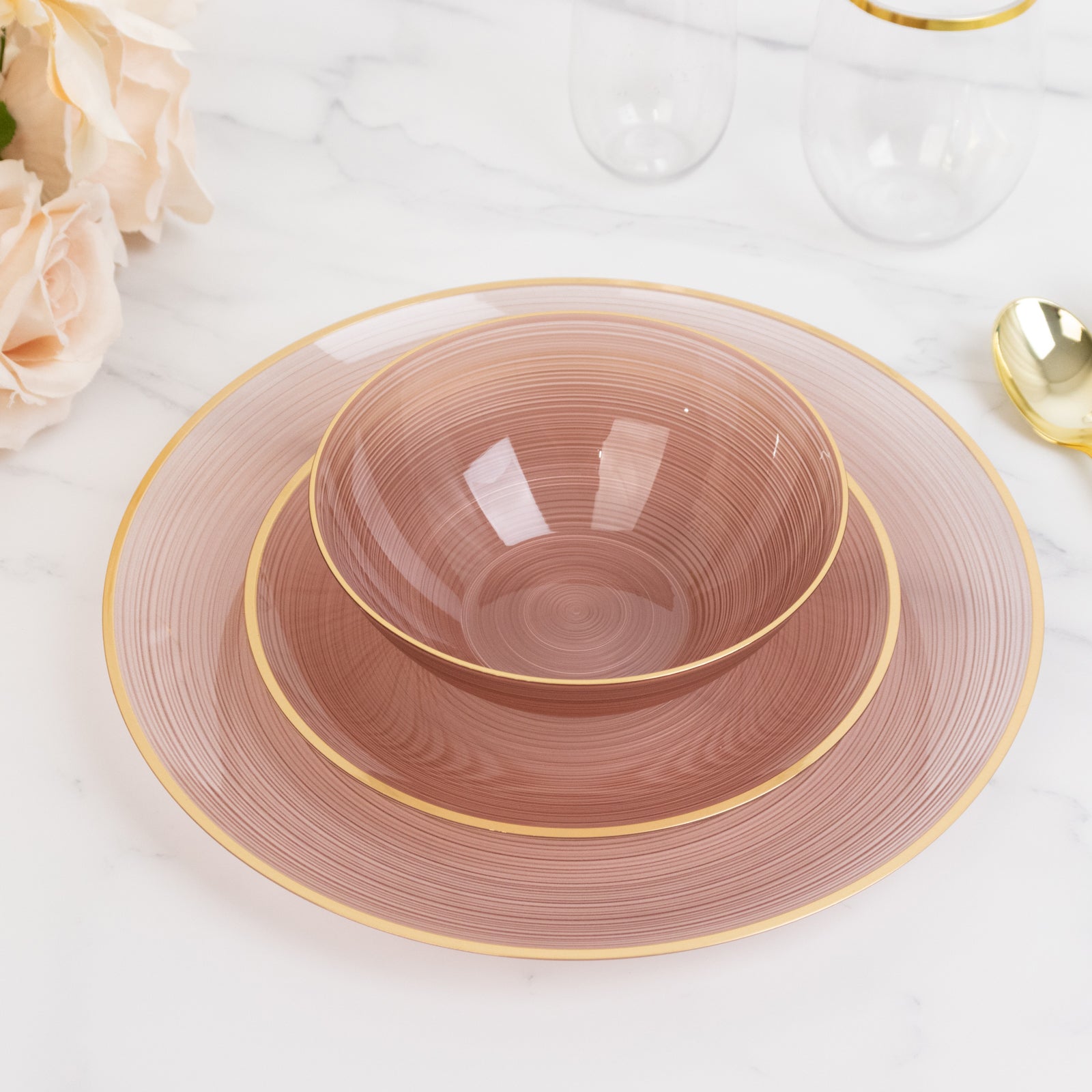 Transparent dusty rose bowl with gold rim, elegant crystal-like swirl design.