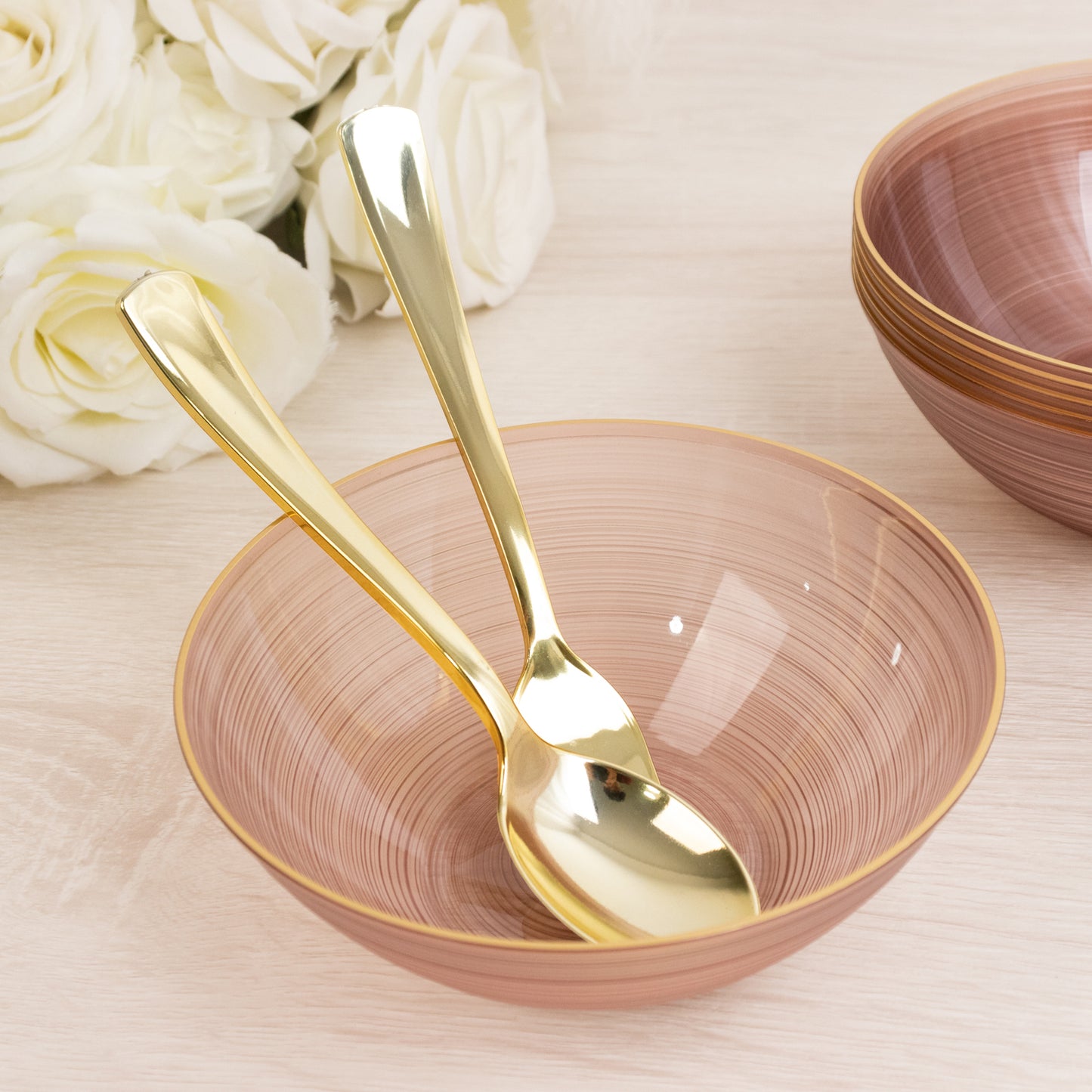 Transparent dusty rose bowls with gold rim and elegant swirl design.