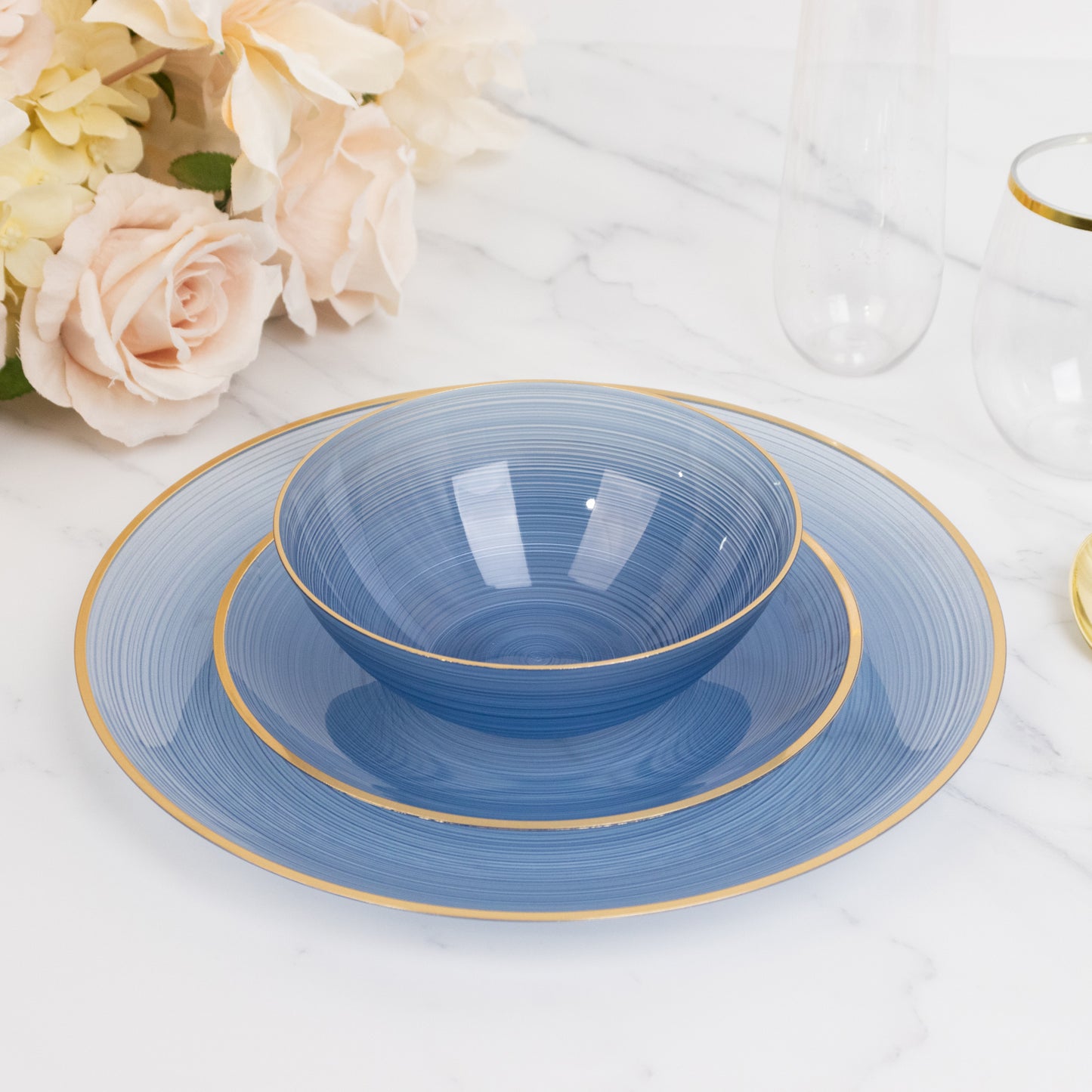 Transparent dusty blue bowl with gold rim, elegant swirl design.