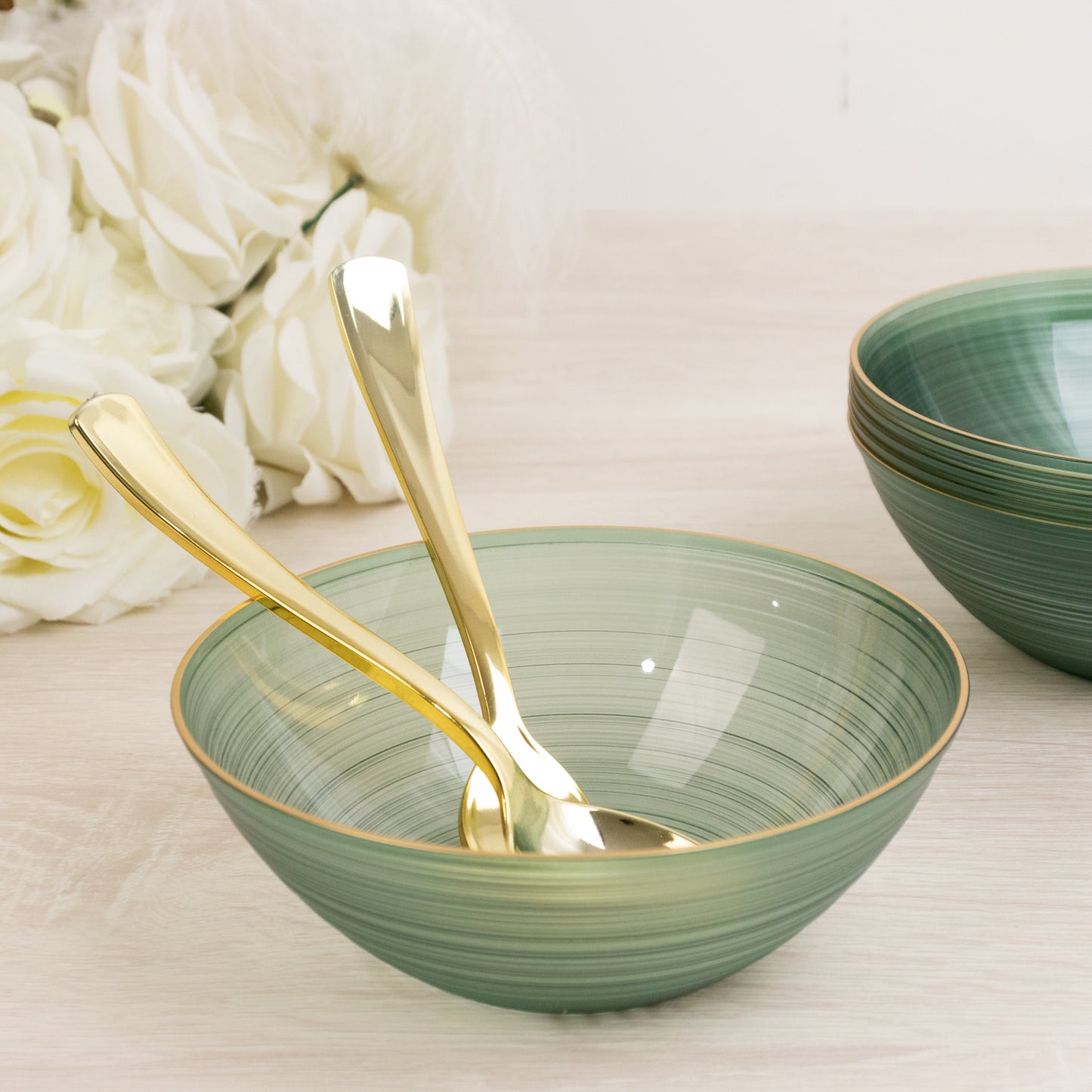 Transparent dusty sage green bowl with gold rim and elegant swirl design.