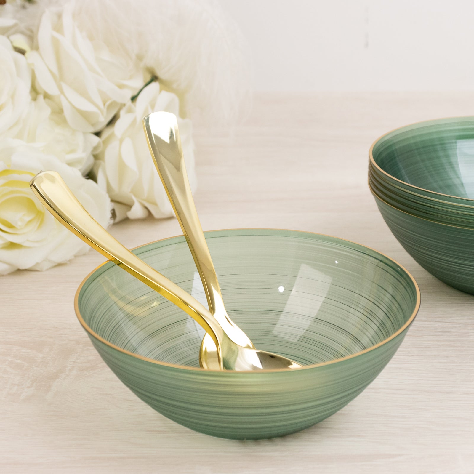 Transparent dusty sage green bowl with gold rim and elegant swirl design.