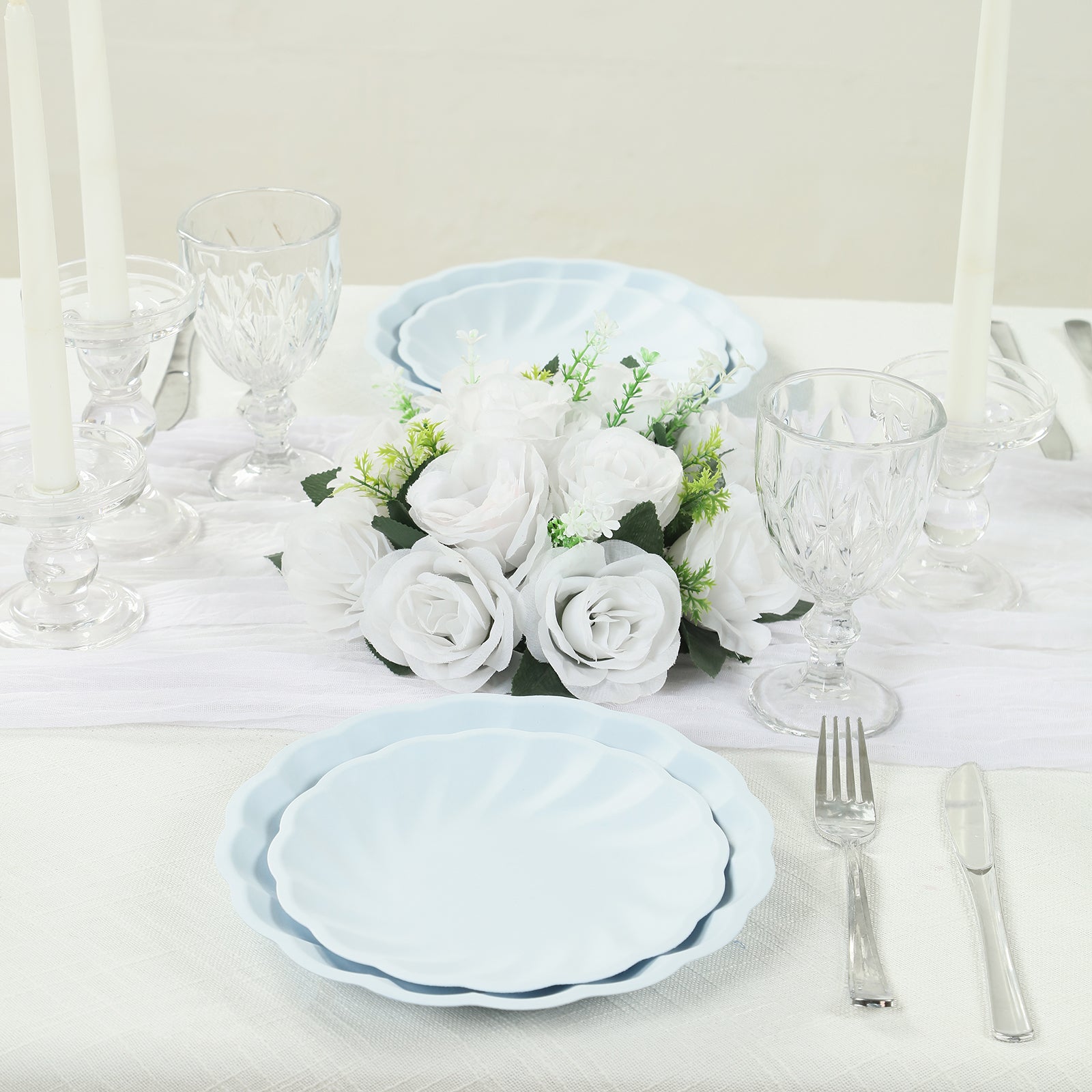 Light blue biodegradable salad plates with scalloped edges on a table setting.