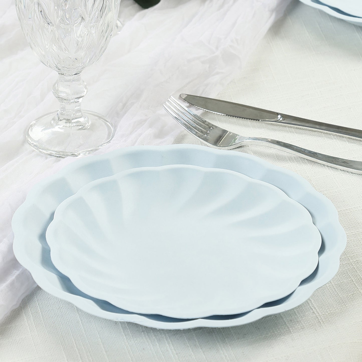 Light blue biodegradable salad plates with swirl scalloped design.